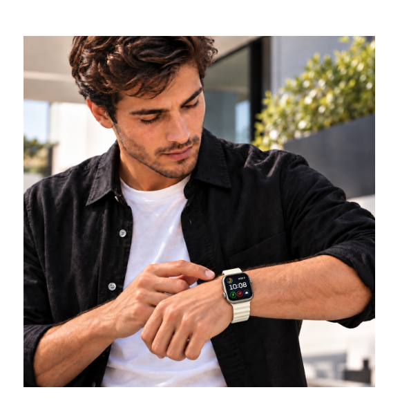 Un hombre con camisa negra y camiseta blanca mira un reloj inteligente en su muñeca.