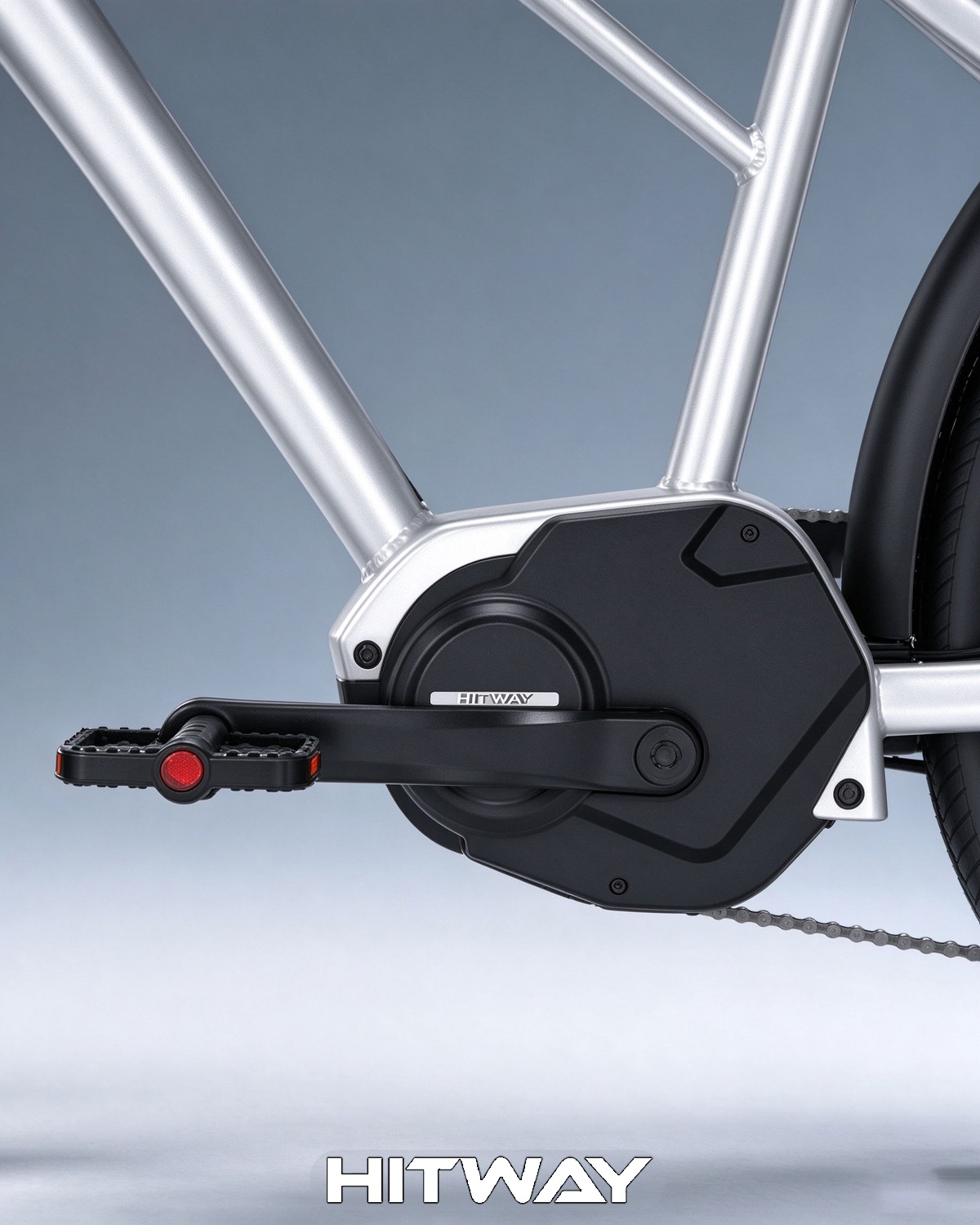 Nahaufnahme eines silbernen Hitway E-Bike-Rahmens mit schwarzem Motor, Kurbelarm und Pedal mit rotem Reflektor.