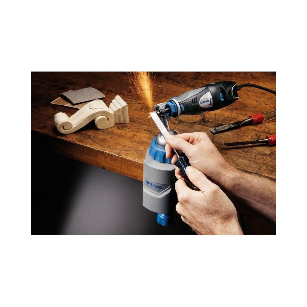 Person schleift Holzteil mit einem Dremel-Multifunktionswerkzeug an der Werkbank.
