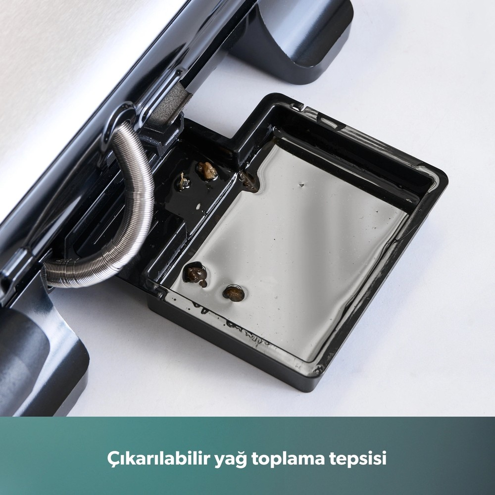 Elektrikli ızgaranın altında sıvı dolu çıkarılabilir siyah yağ toplama tepsisi.