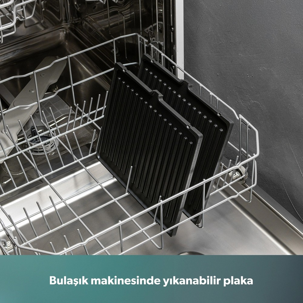Açık bir bulaşık makinesinin sepetinde iki adet siyah oluklu ızgara plakası dikey olarak duruyor.