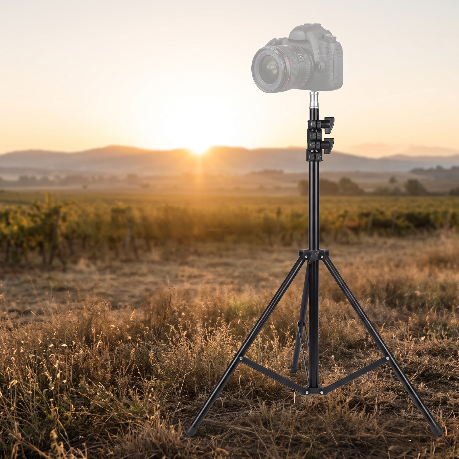Una cámara en un trípode en un campo cubierto de hierba al atardecer.
