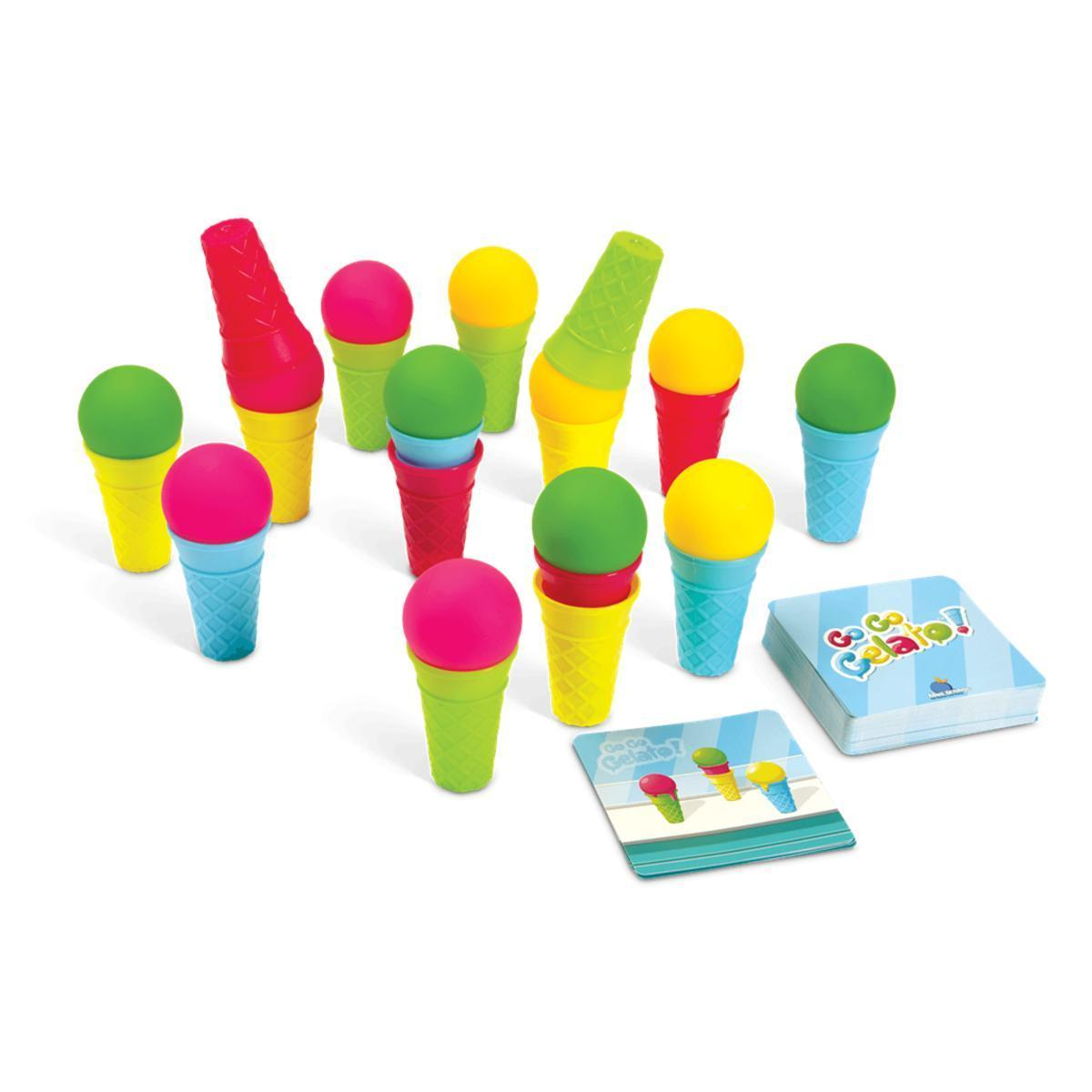 Juguetes de helado de plástico coloridos y cartas de juego en superficie blanca.