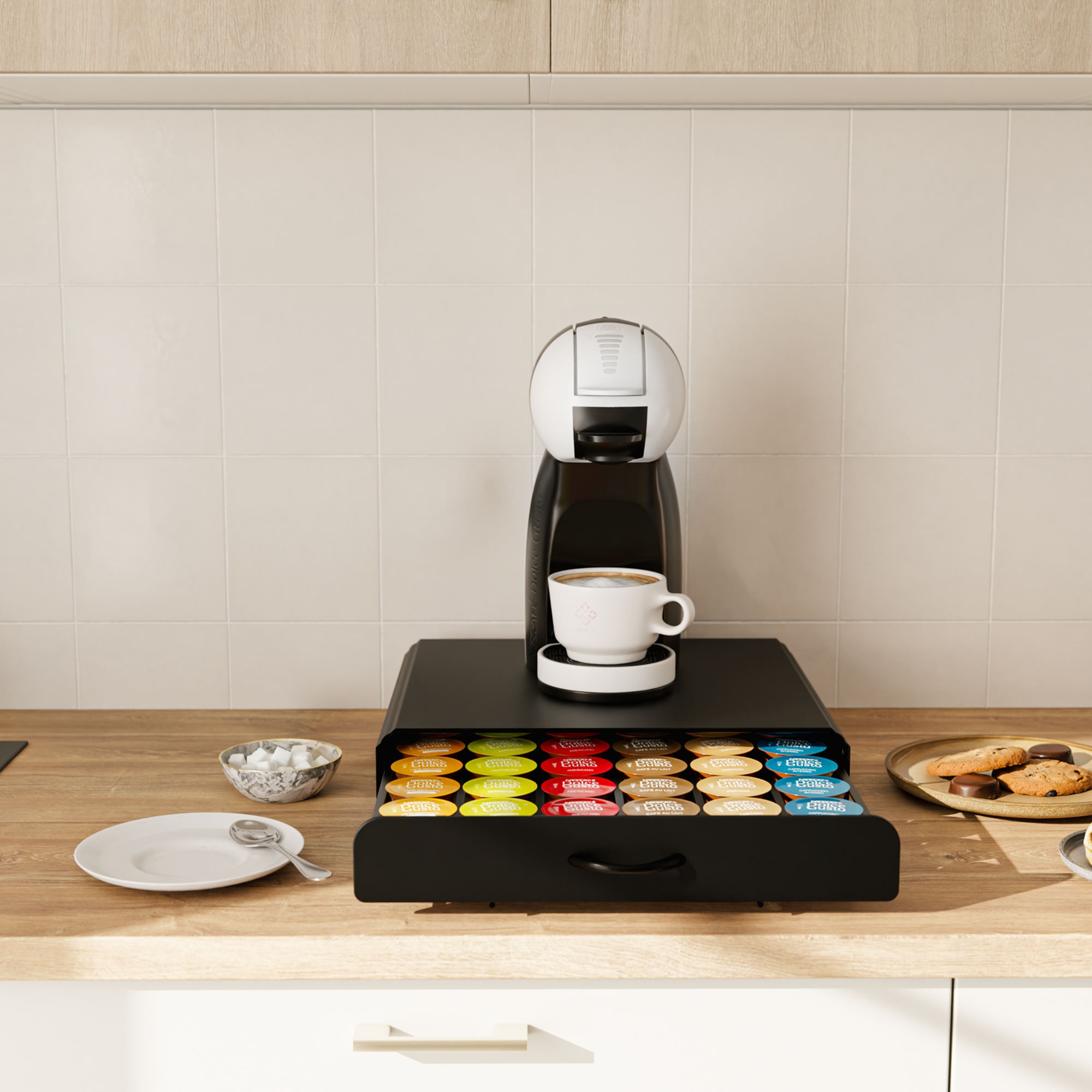 Kaffeemaschine auf einer Kapselschublade mit Tasse, Zucker und Keksen in der Küche.
