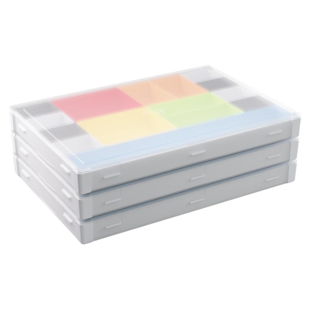 Tres cajas de almacenamiento blancas apiladas con tapas transparentes y compartimentos interiores coloridos.