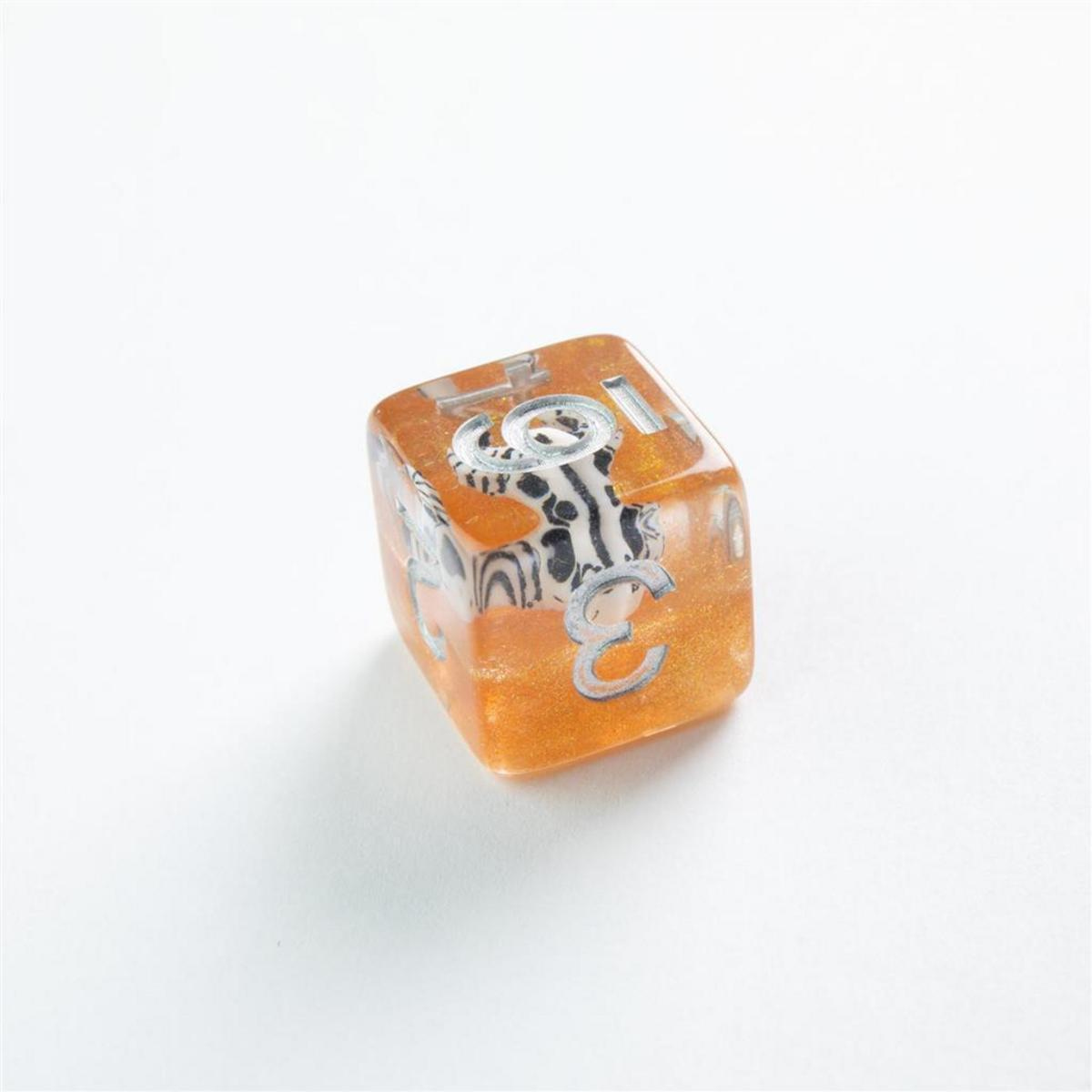Un dado translúcido naranja con números plateados y una figura de cebra dentro sobre fondo blanco.