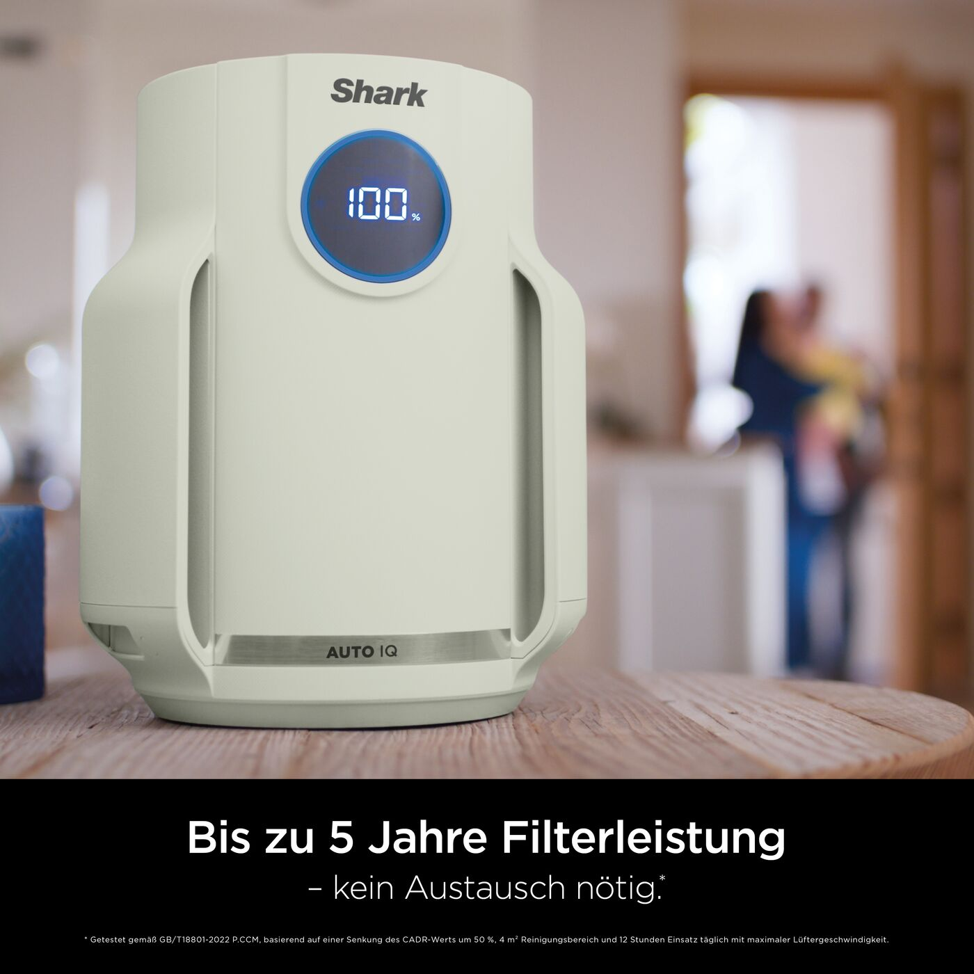 Ein cremeweißer Shark Luftreiniger auf einem Holz Tisch mit digitalem Display.