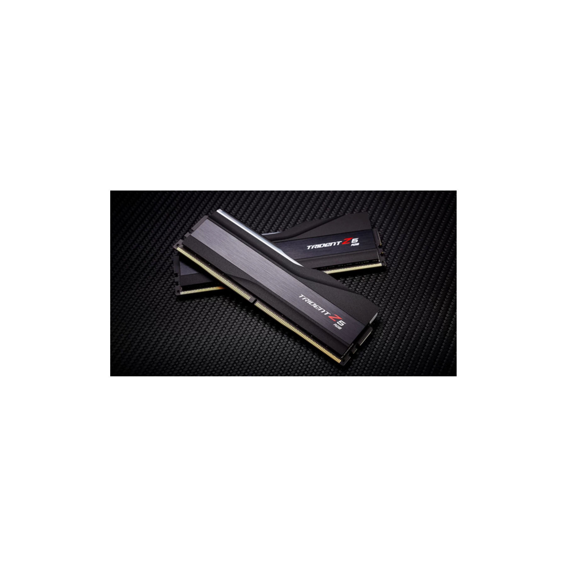 Dwa czarne moduły RAM Trident Z5 RGB na ciemnej powierzchni z włókna węglowego.