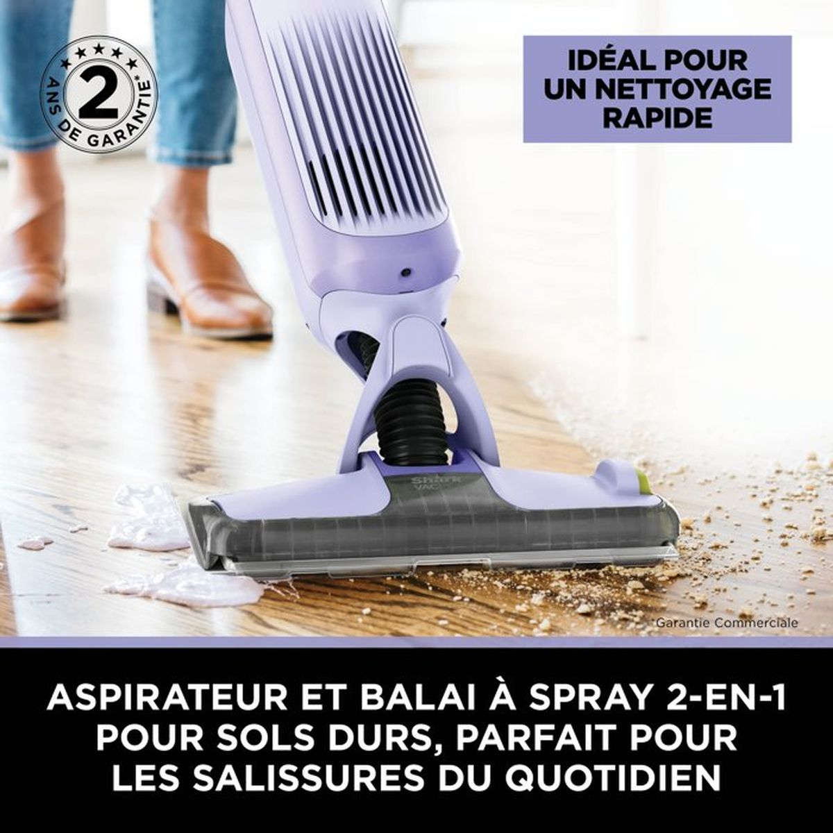 Un aspirapolvere e scopa viola 2 in 1 pulisce lo sporco sul pavimento.