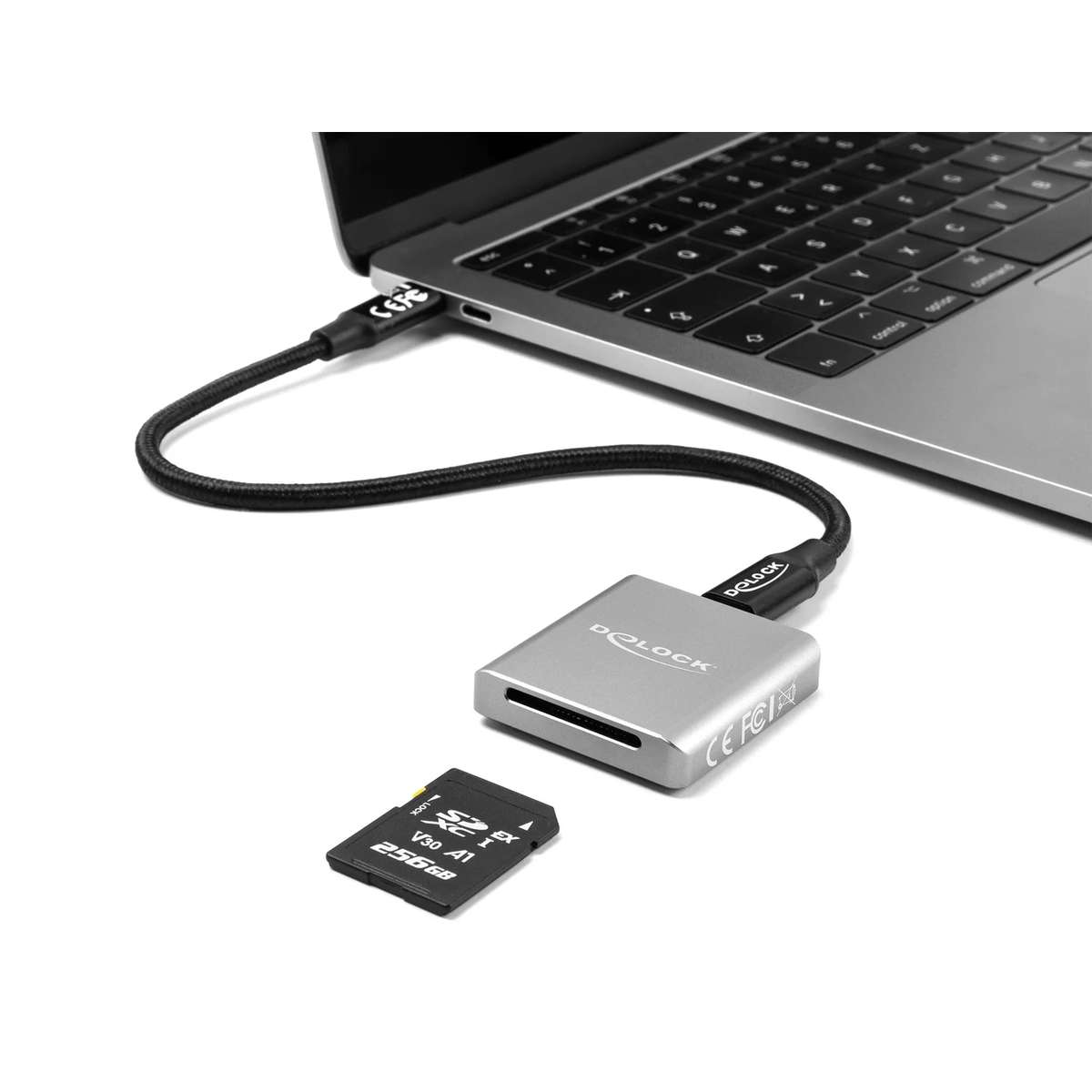 Ein silberner Delock Kartenleser ist per Kabel mit einem Laptop verbunden, eine 256GB SD-Karte liegt daneben.