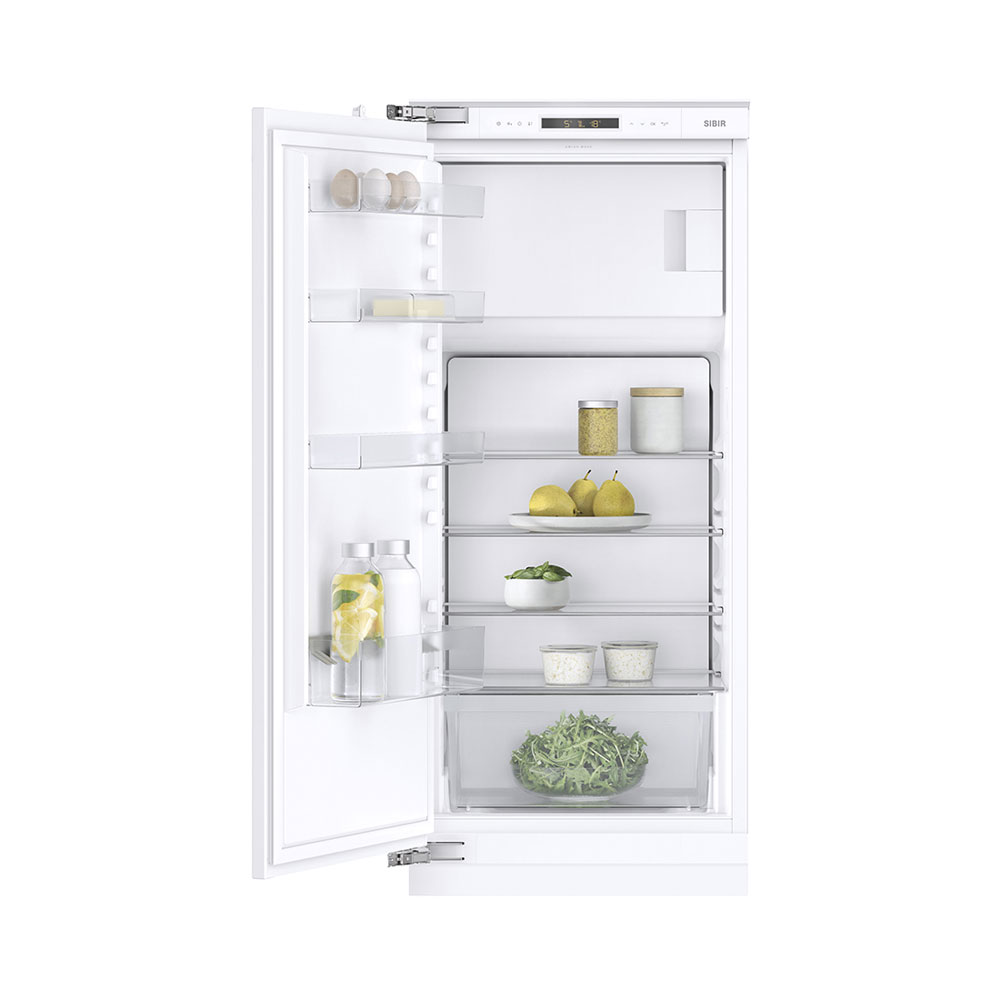 Ein offener weißer Einbaukühlschrank mit Glasböden und gefüllten Fächern.