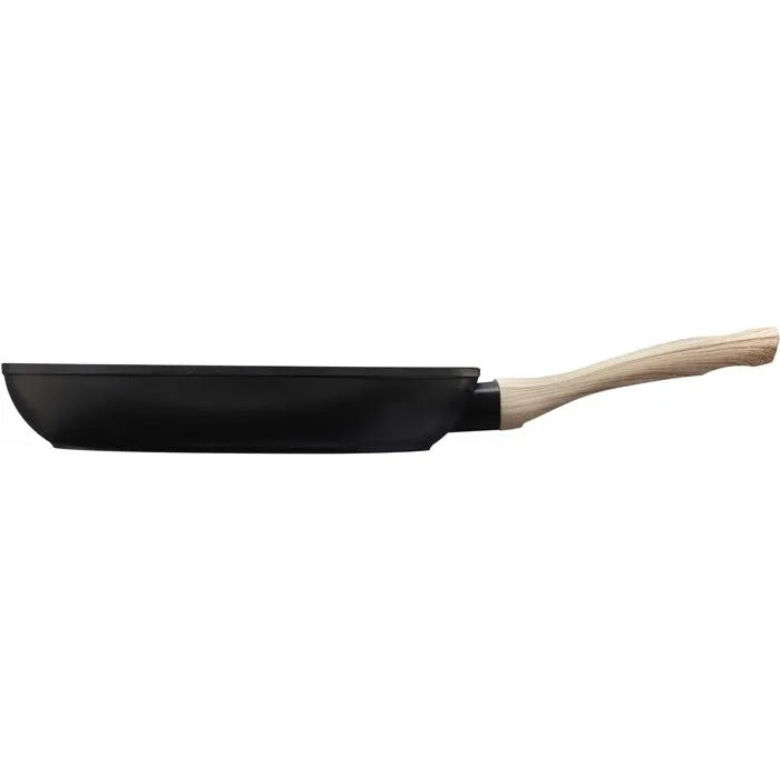 Eine schwarze Bratpfanne mit hellem Holzgriff vor weißem Hintergrund.