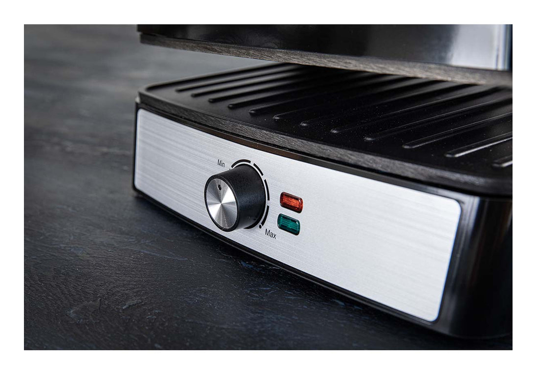 Una parrilla eléctrica de mesa con panel de control plateado, perilla giratoria de Min a Max y dos luces piloto.
