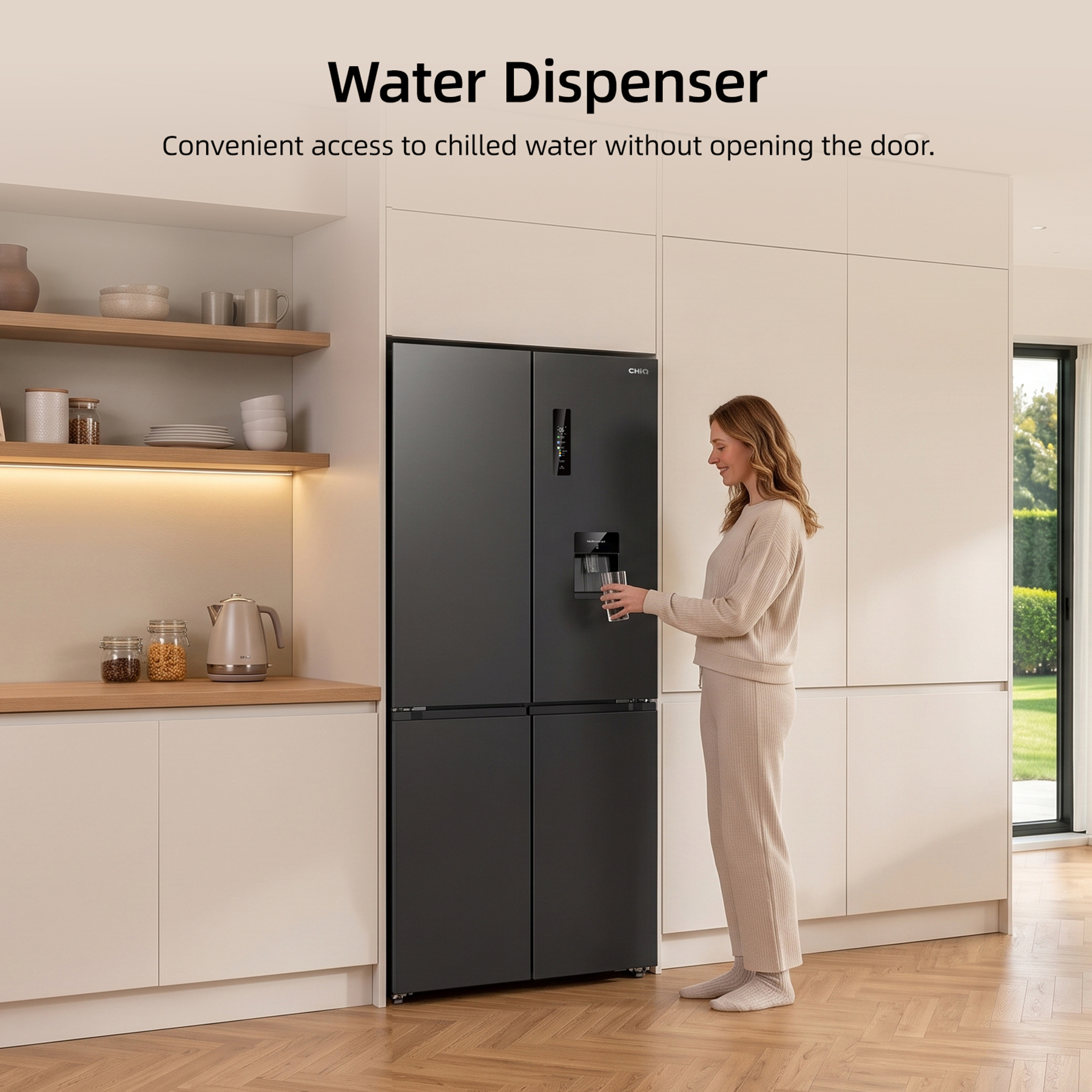 Donna che riempie un bicchiere d'acqua da un distributore su un frigorifero scuro in una cucina moderna.