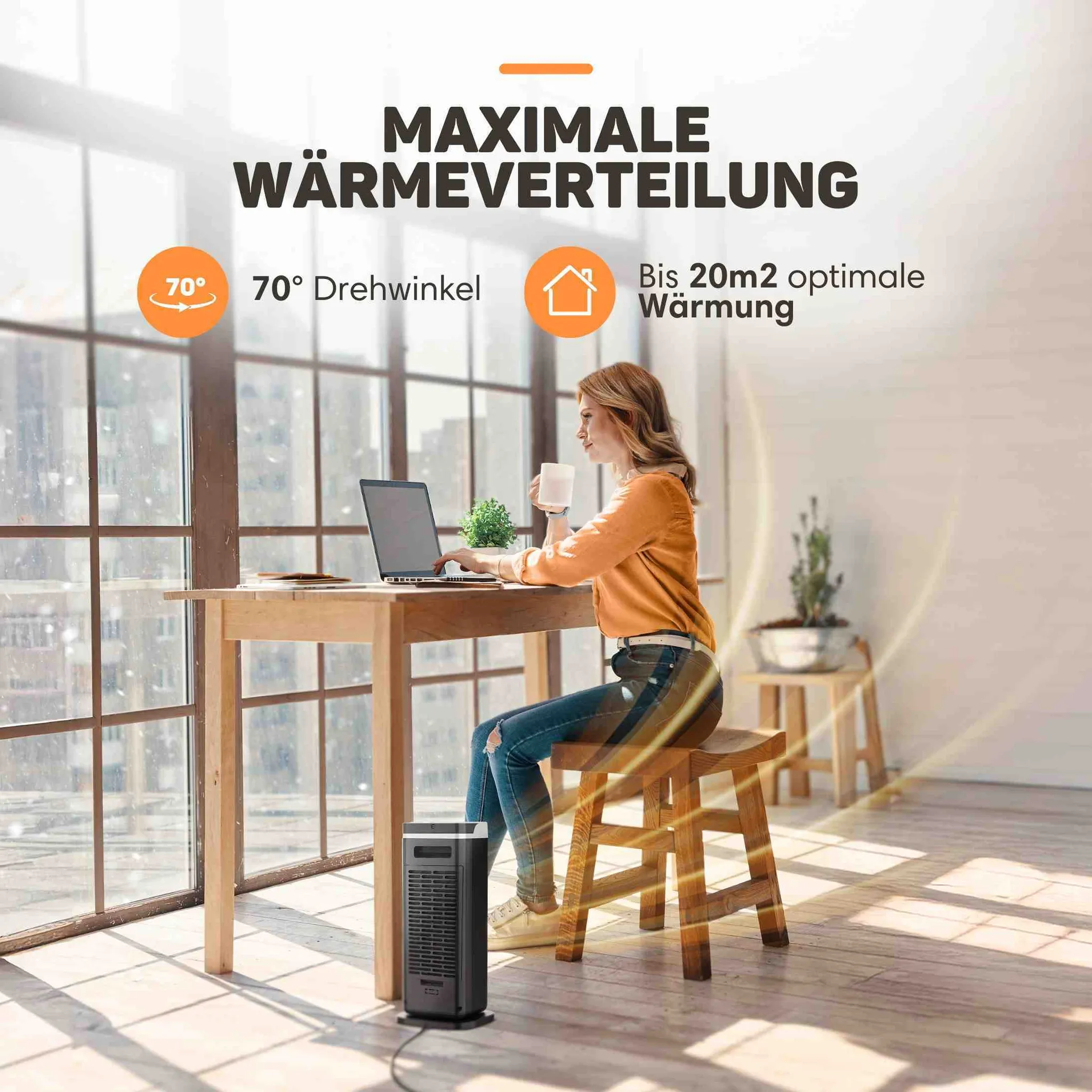 Eine Frau arbeitet an einem Laptop in einem Raum, während ein Heizlüfter für warme Luft sorgt.