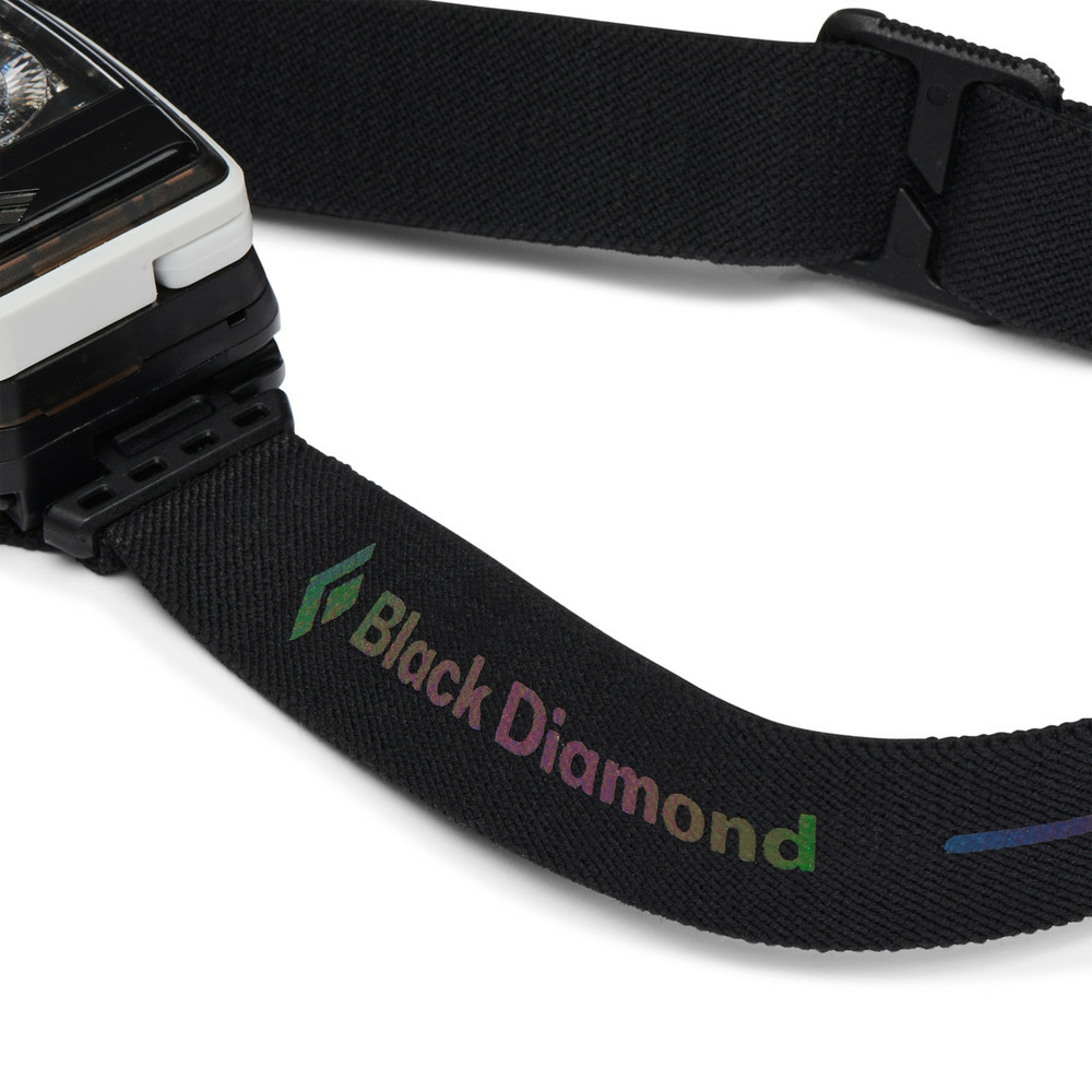 Schwarzes Stirnband mit irisierendem Black Diamond Logo und weißem Lampenkörper auf weißem Hintergrund.