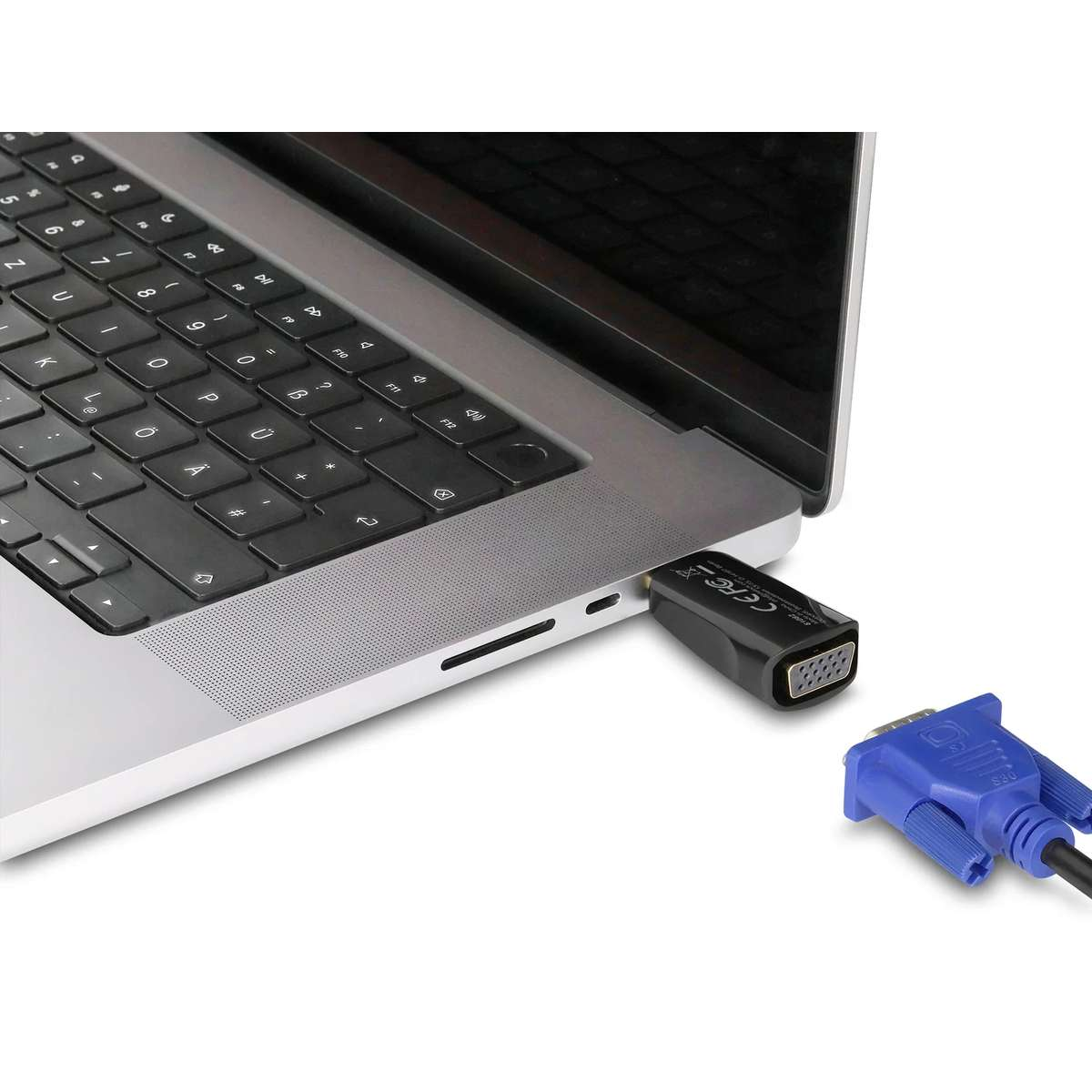 Ein VGA-Adapter steckt im USB-C-Anschluss eines Laptops, ein blaues VGA-Kabel liegt bereit.