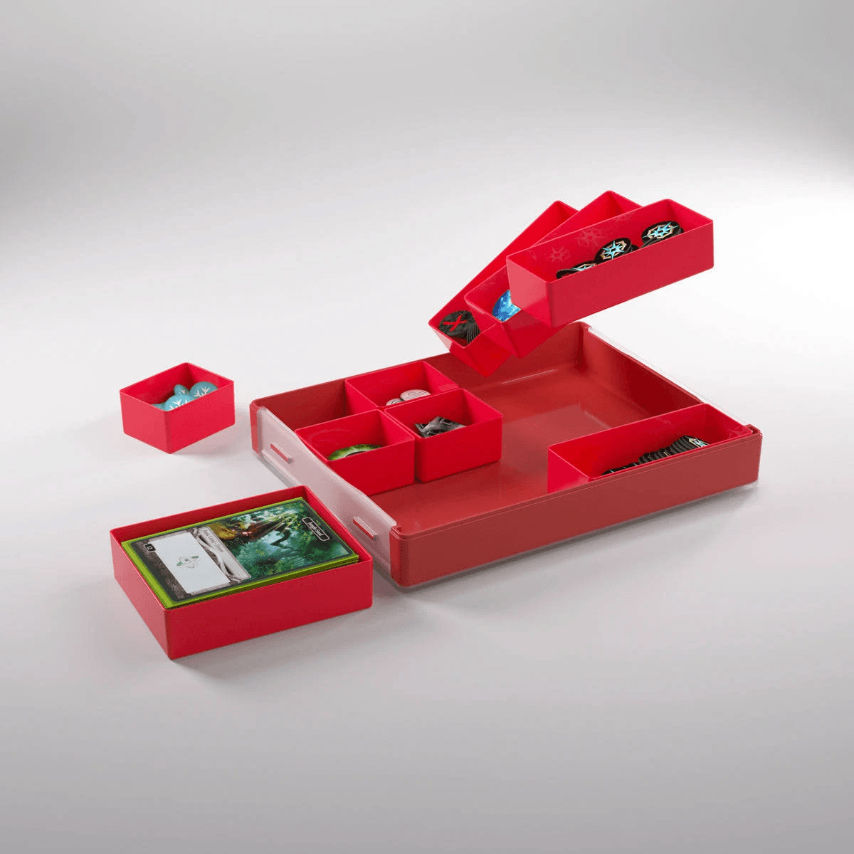 Cajas rojas de juegos de mesa con cartas y fichas sobre fondo claro.