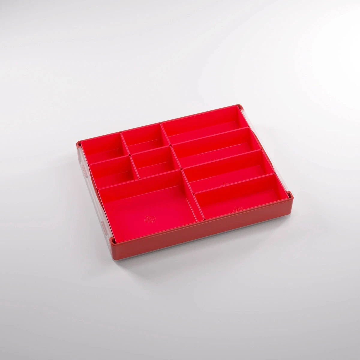 Un organizador de cajones de plástico rojo con varios compartimentos sobre fondo blanco.