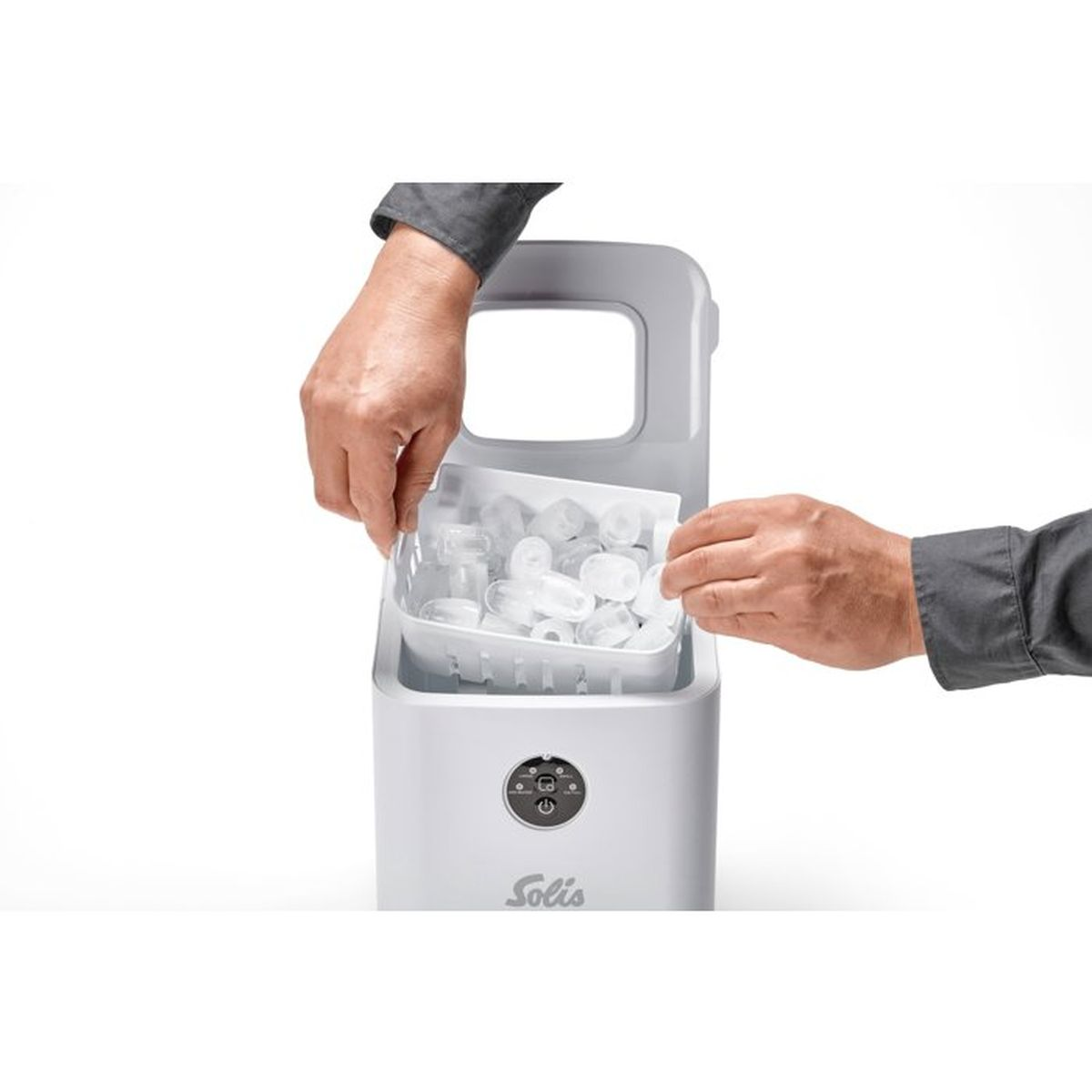 Hände entfernen einen Korb voller Eiswürfel aus einer weißen Eismaschine.