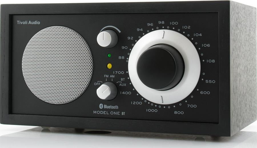 Schwarzes Tivoli Audio Model One BT Radio mit silbernem Lautsprecher und Drehreglern auf weißem Grund.