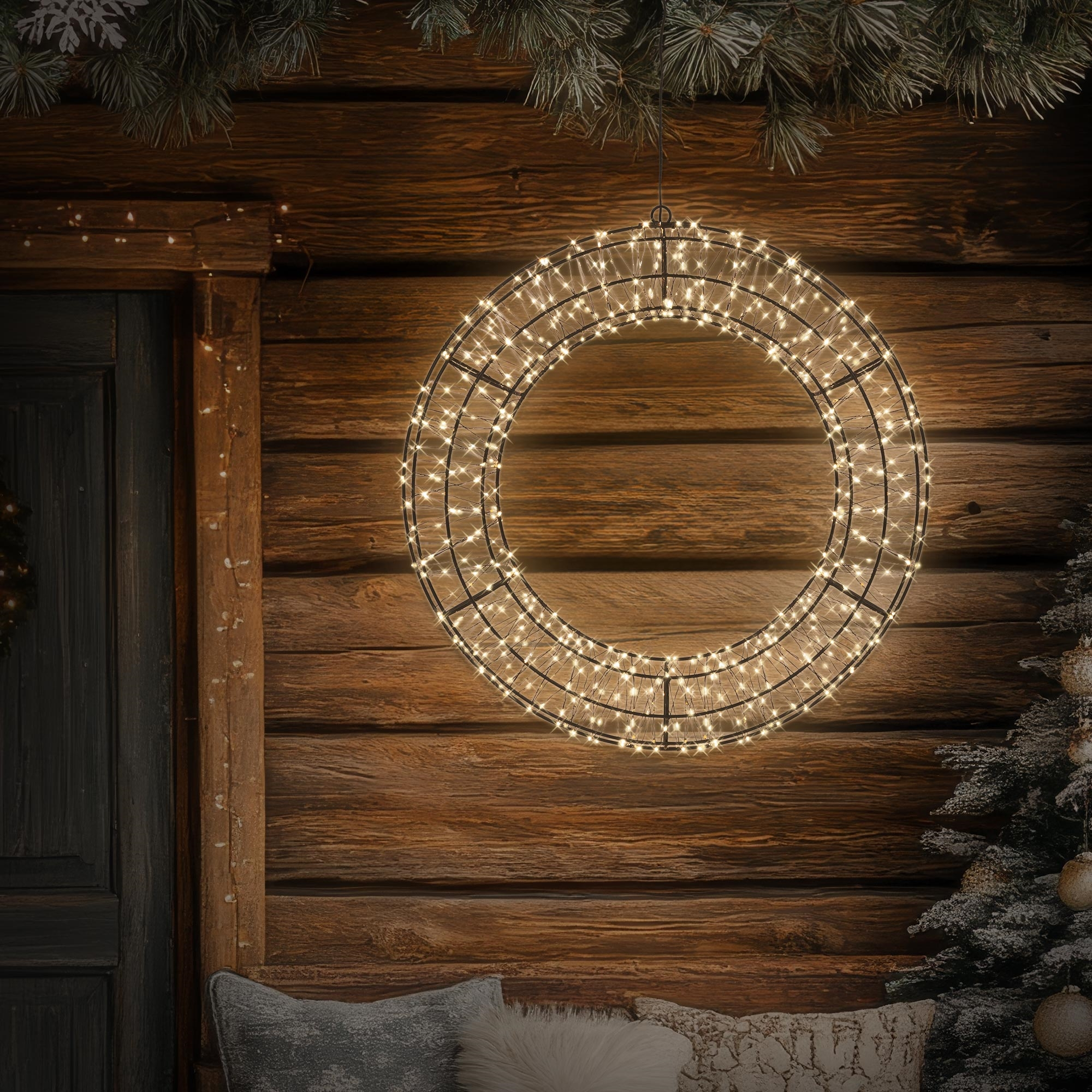 Beleuchteter LED-Ring hängt vor Holzwand mit Tür und Tannenbaum.