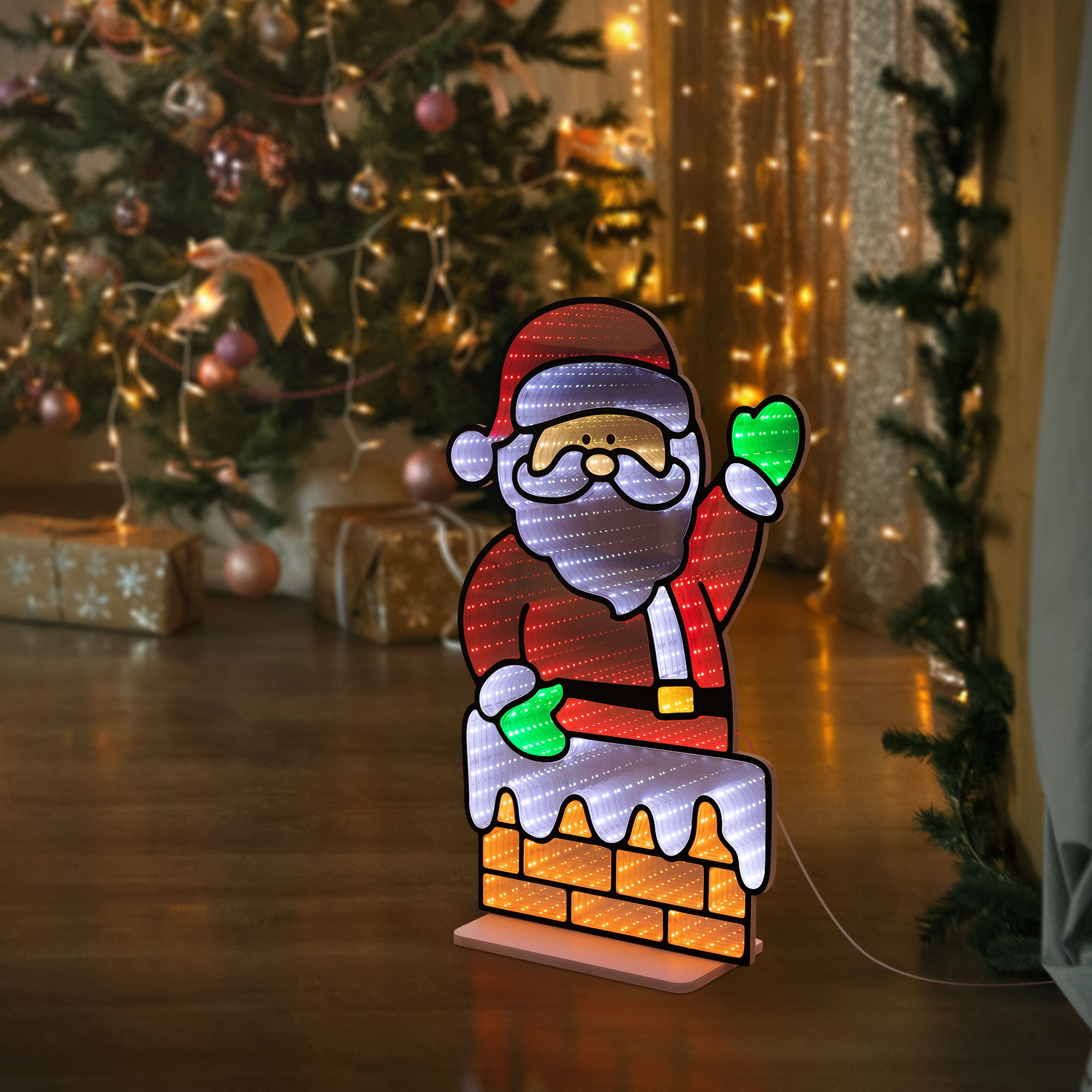 Beleuchtete Weihnachtsmannfigur auf einem Schornstein vor einem Weihnachtsbaum.