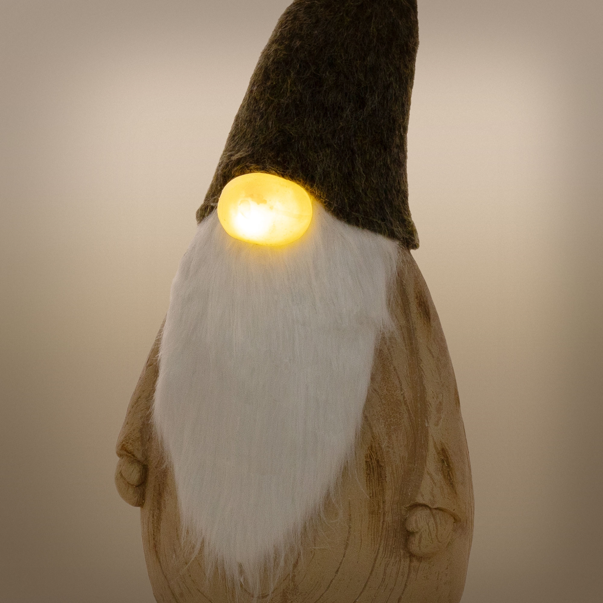 Eine hölzerne Wichtelfigur mit weißem Bart, dunkler Mütze und einer leuchtenden gelben Nase vor neutralem Hintergrund.