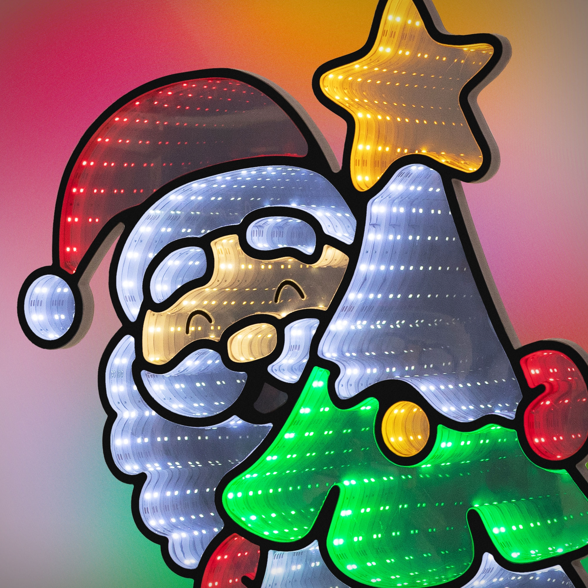 Bunt beleuchtete Weihnachtsmann- und Tannenbaum-LED-Figuren vor einem warmen, farbigen Hintergrund.