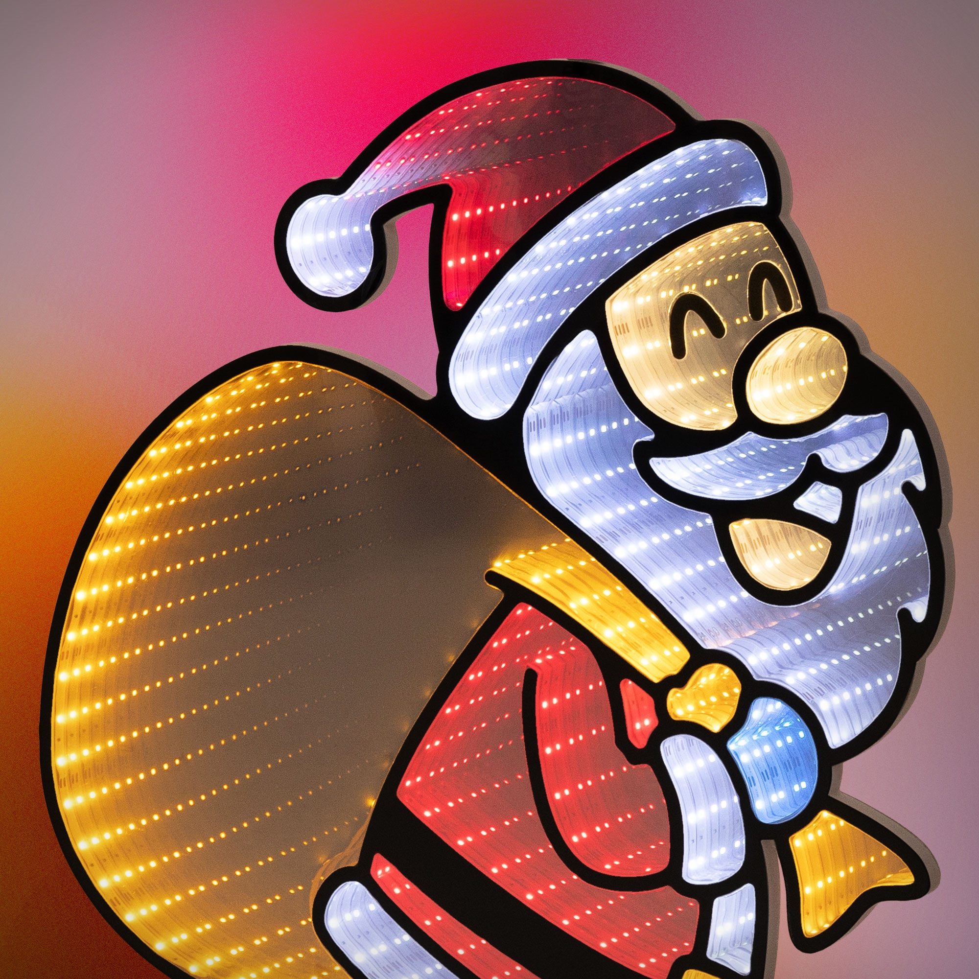 Eine leuchtende LED-Weihnachtsmann-Silhouette mit einem großen gelben Sack vor rosa Hintergrund.