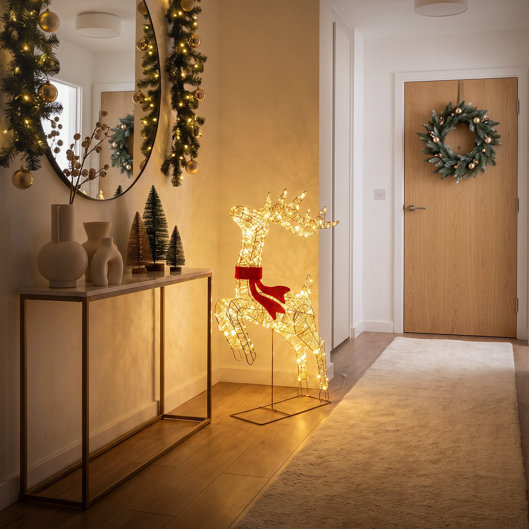 Flur mit Weihnachtsdeko, leuchtendem Rentier, Kranz und Konsole.