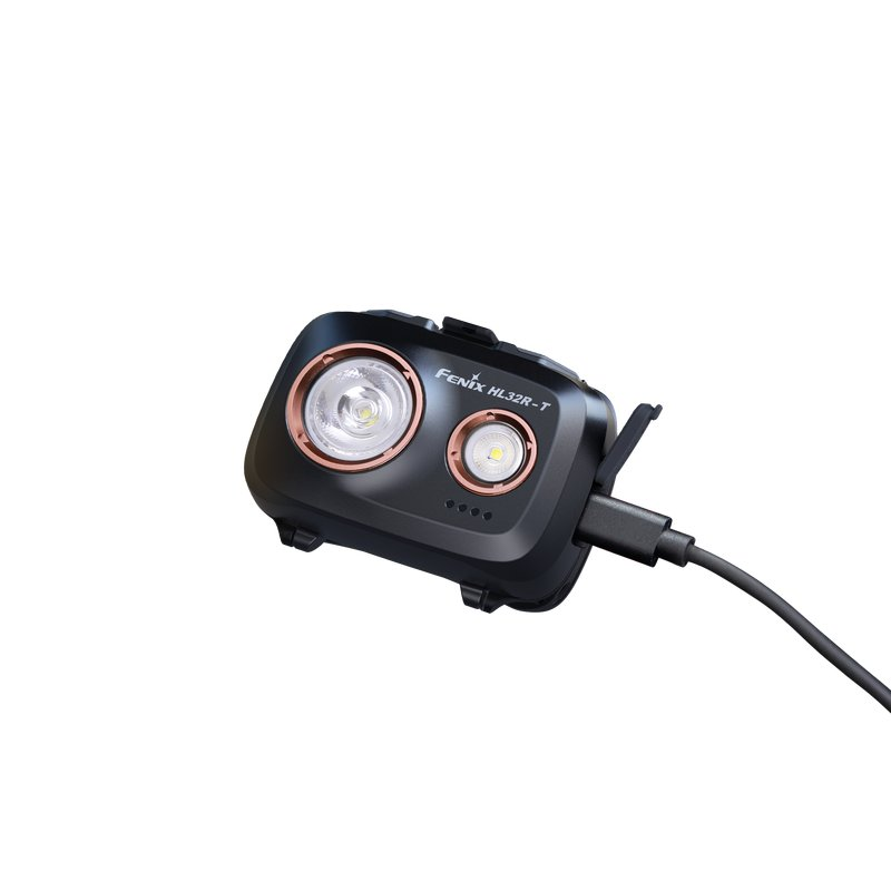Schwarze Fenix HL32R-T Stirnlampe mit Kupferakzenten wird über ein USB-C-Kabel aufgeladen.