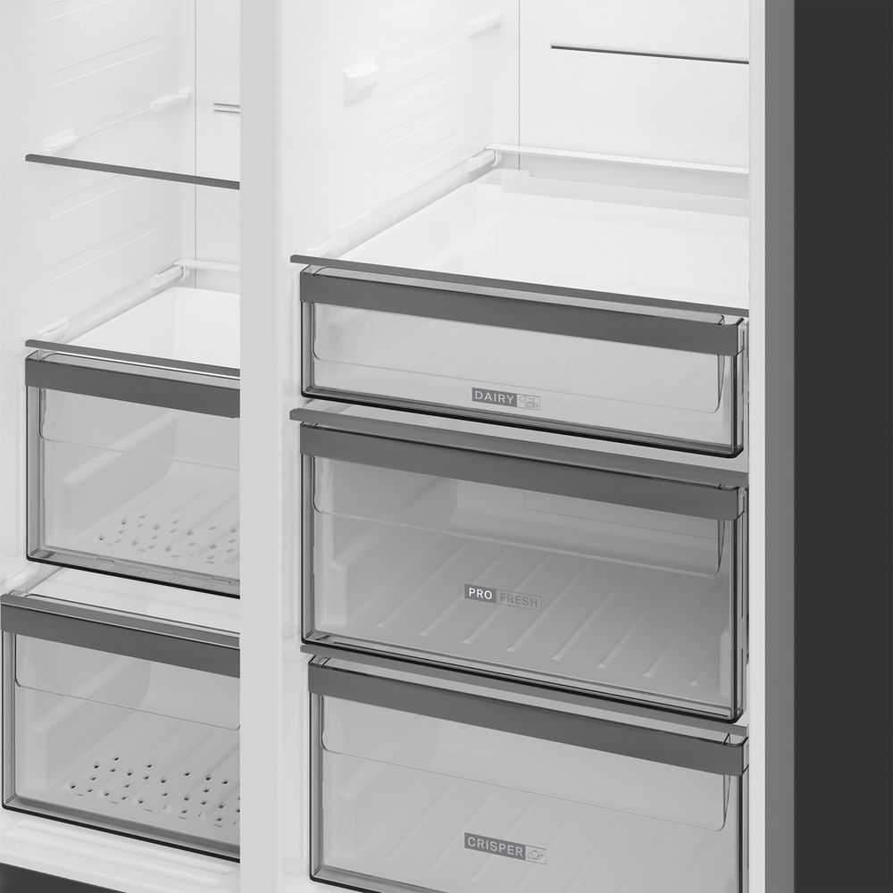 Interior de refrigerador blanco abierto con cajones transparentes etiquetados como Dairy, Pro Fresh y Crisper.