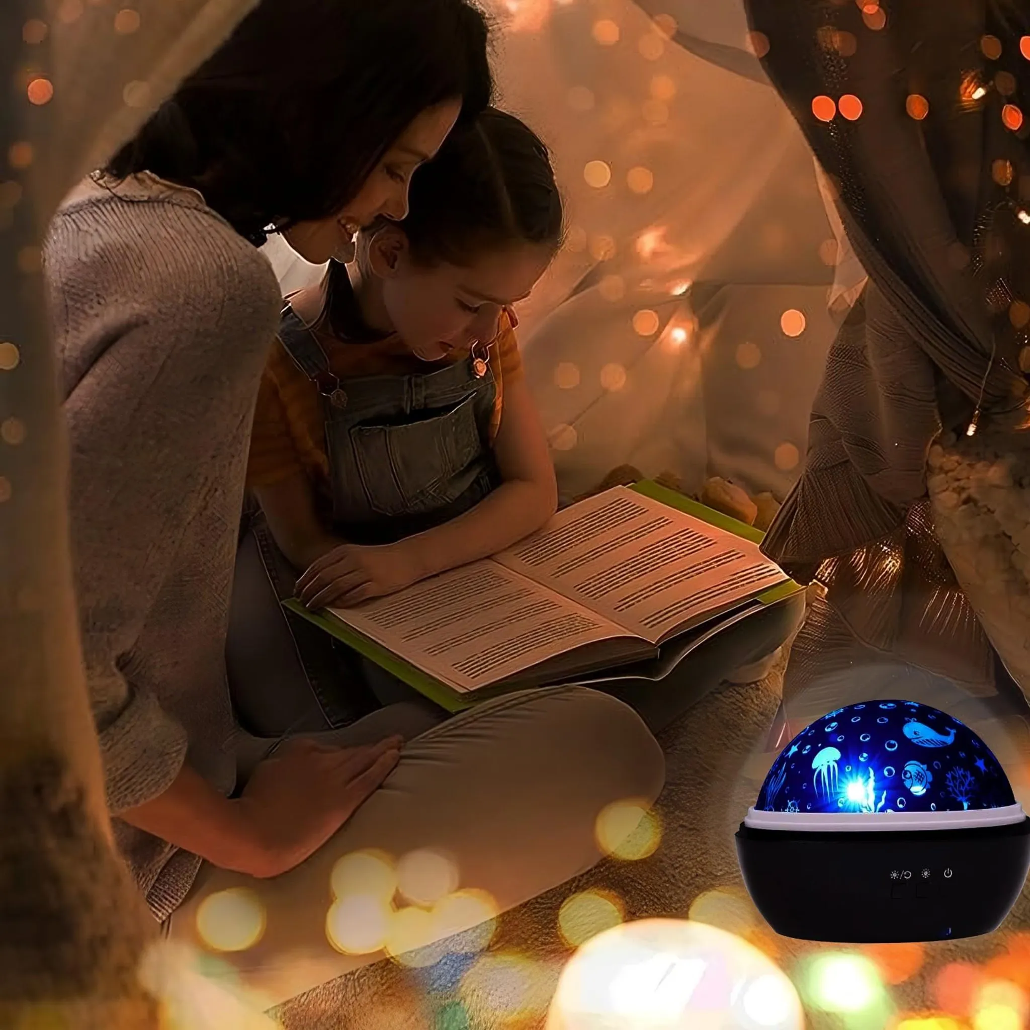 Eine Frau und ein Mädchen lesen zusammen ein Buch in einem beleuchteten Zelt neben einer Projektorlampe.