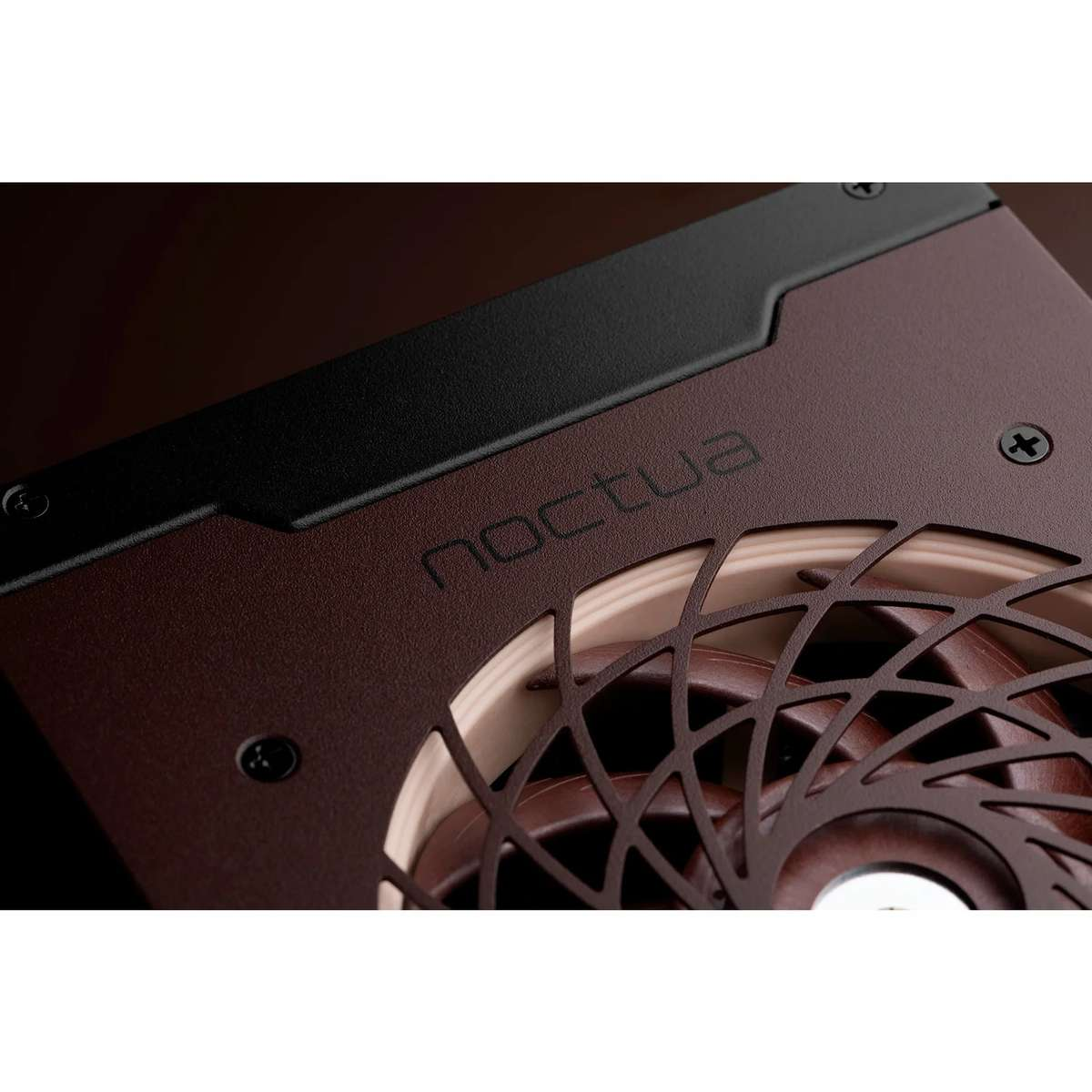 Gros plan sur un ventilateur Noctua marron avec cadre noir et grille de protection.