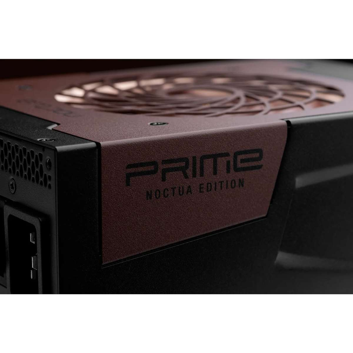 Gros plan sur un bloc d'alimentation Prime Noctua Edition noir et marron avec une grille de ventilateur couleur cuivre.