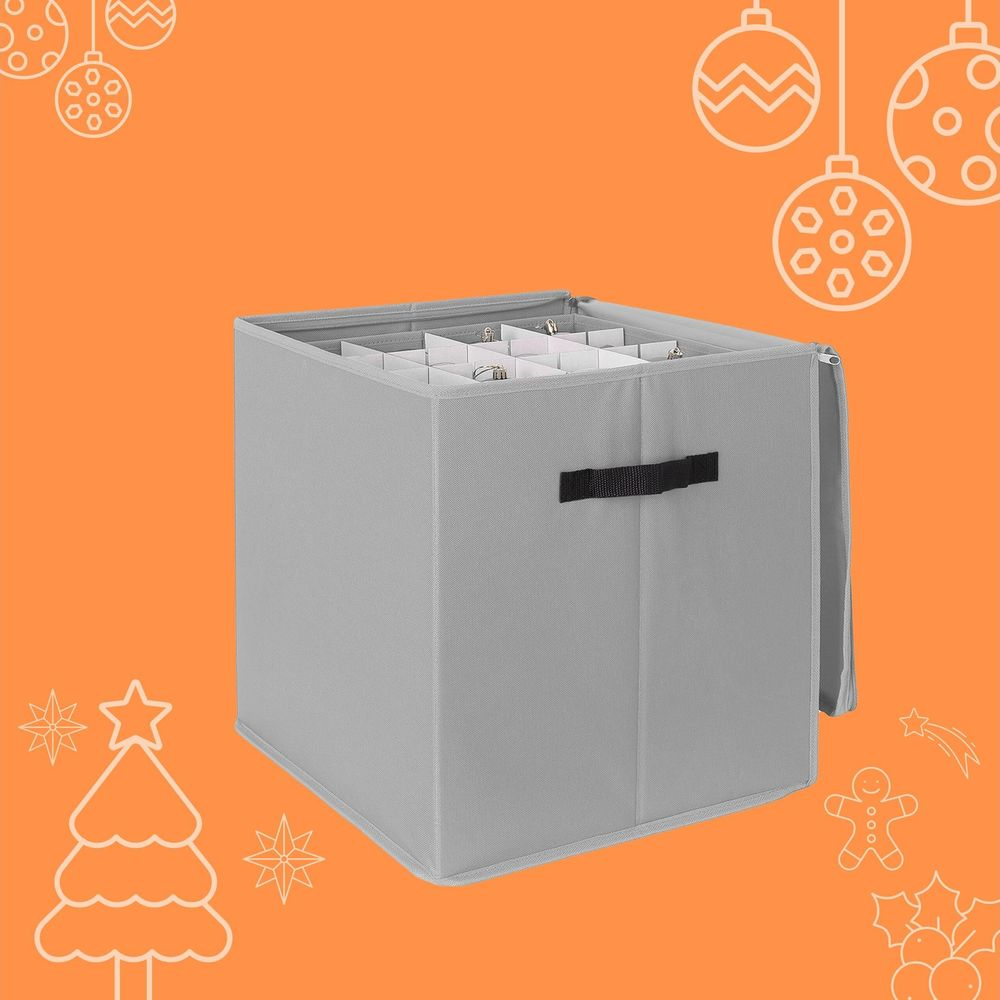 Graue Stoff-Weihnachtskugelaustauschbox auf orangefarbenem Hintergrund mit weihnachtlichen Umrissen.