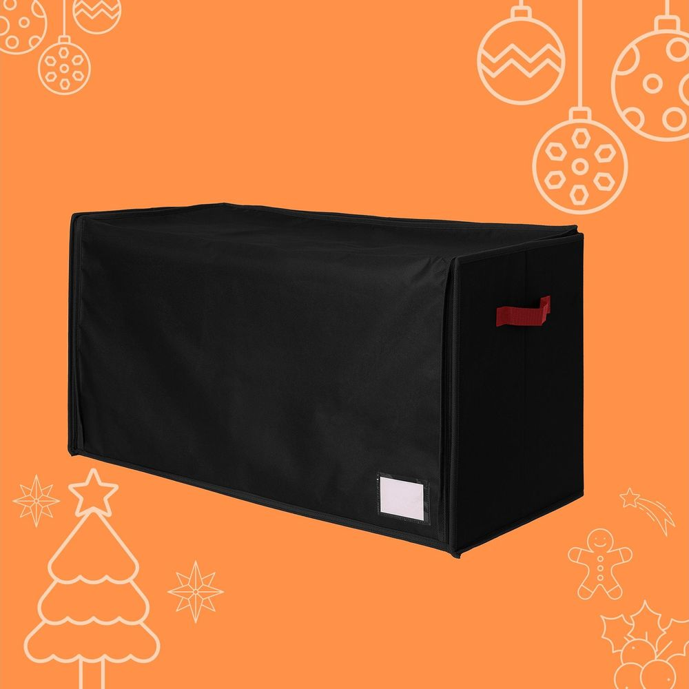 Eine schwarze Aufbewahrungsbox mit roten Griffen vor einem orangefarbenen Hintergrund mit Weihnachtsmotiven.