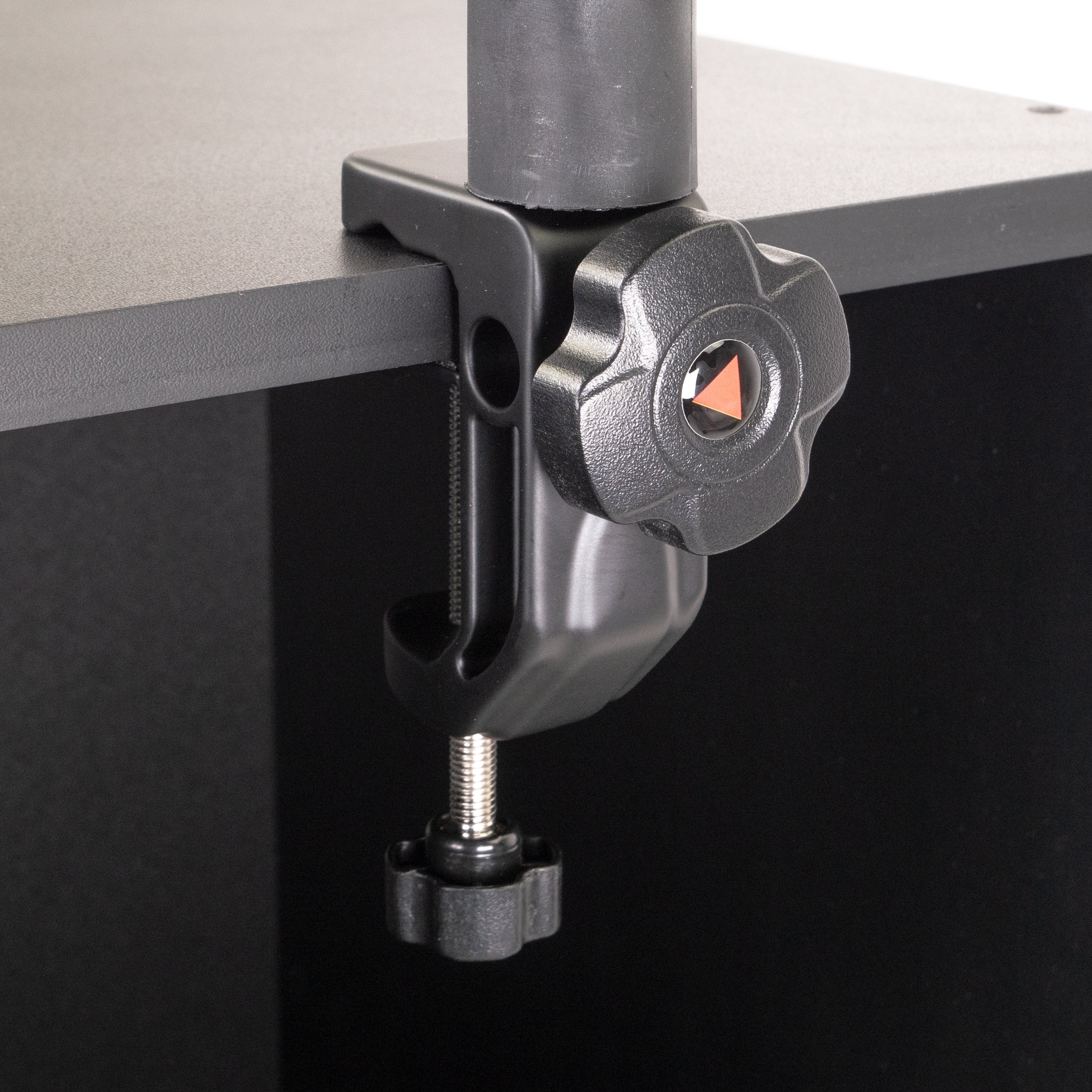 Eine schwarze Schreibtischklemme mit Einstellknopf an einer schwarzen Oberfläche.