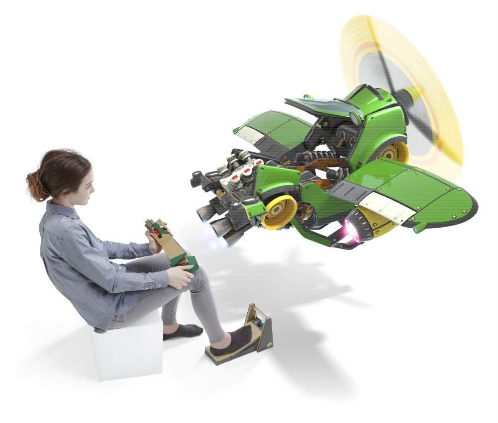 Ein Mädchen sitzt und bedient ein grünes Spielzeugflugzeug. Ein Propeller dreht sich. Das Flugzeug hat mehrere Düsen.