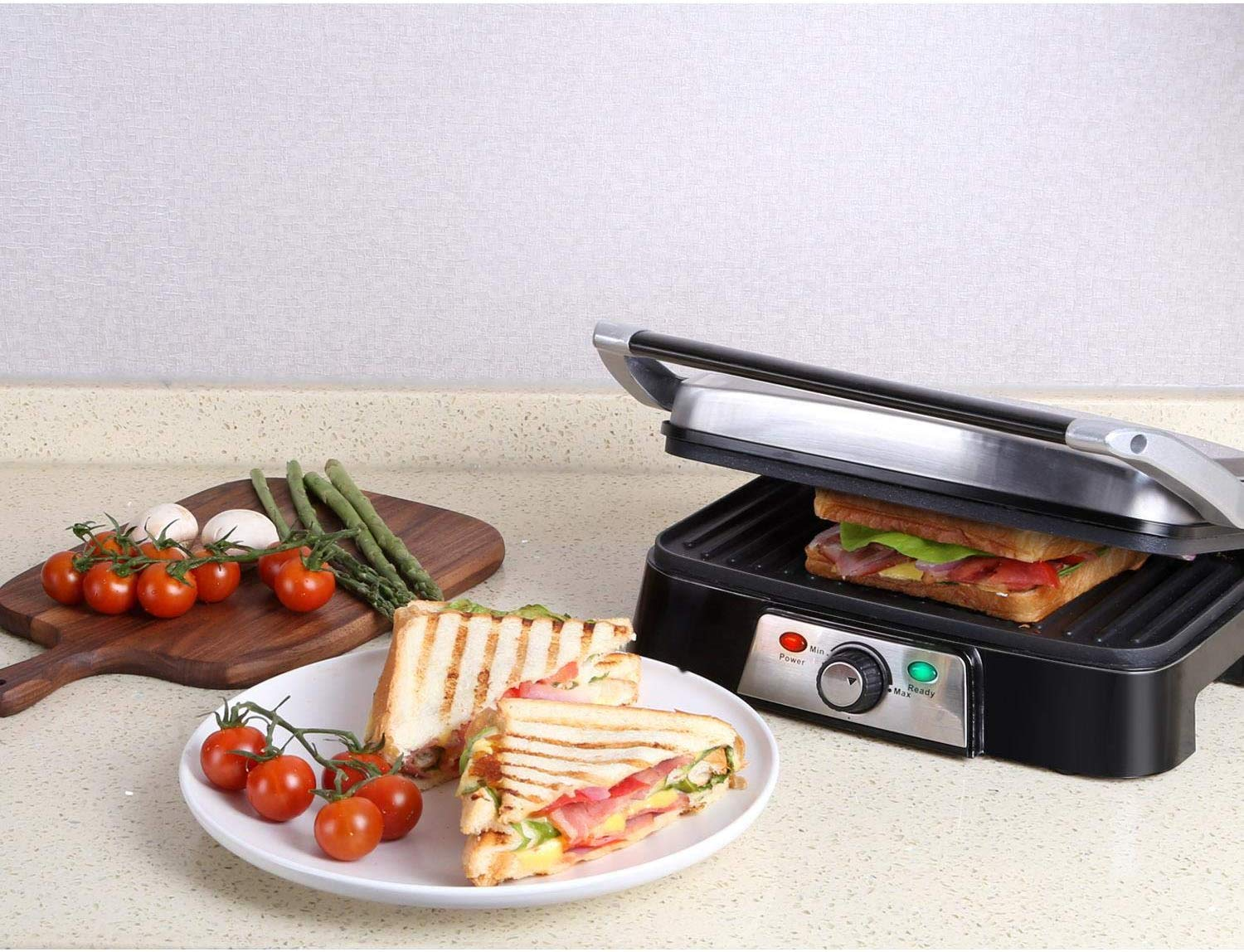 Griglia per sandwich con panini e pomodori. Panini a fette e pomodorini su un piatto.