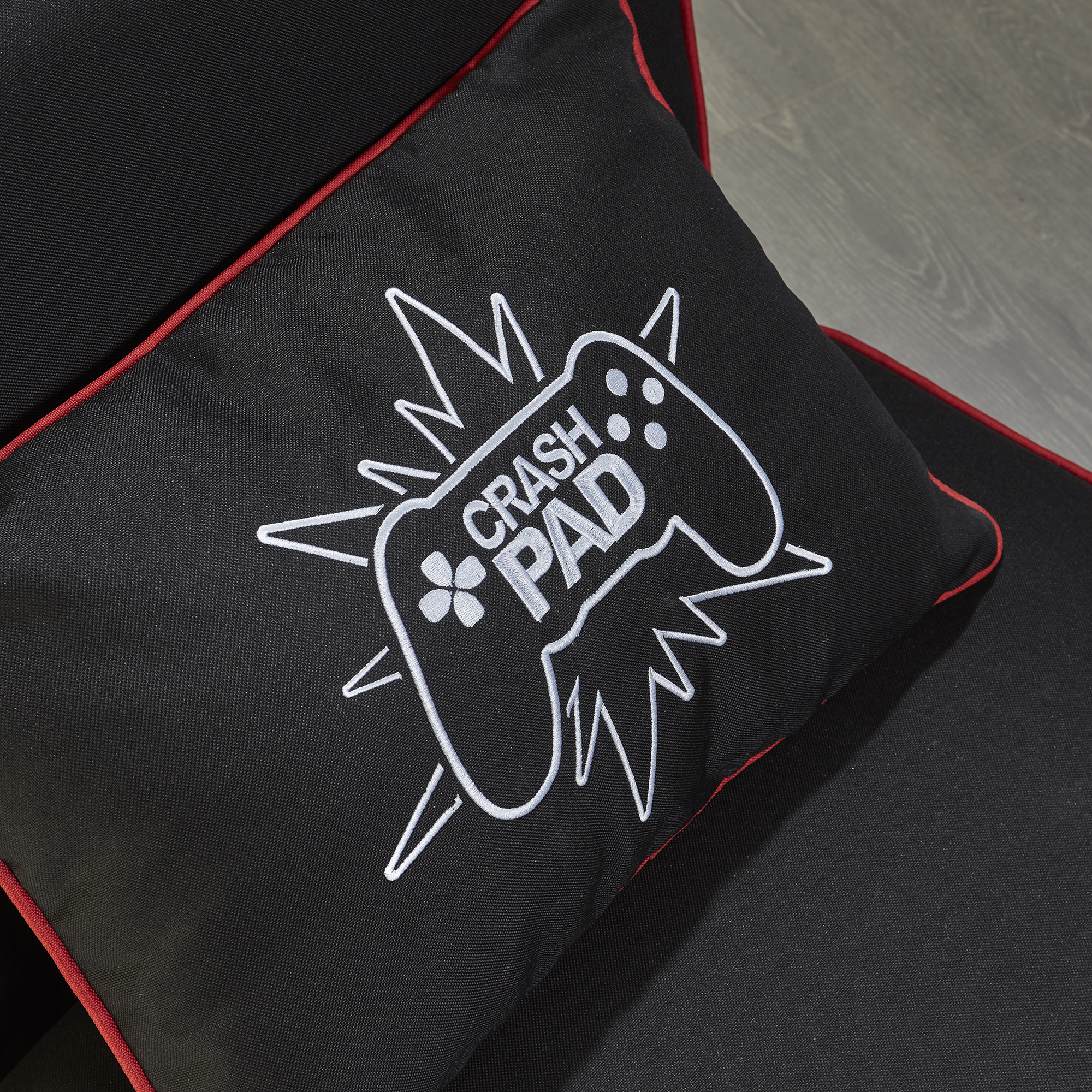 Schwarzes Kissen mit weißem Crash Pad Logo. Roter Rand um den Rand.