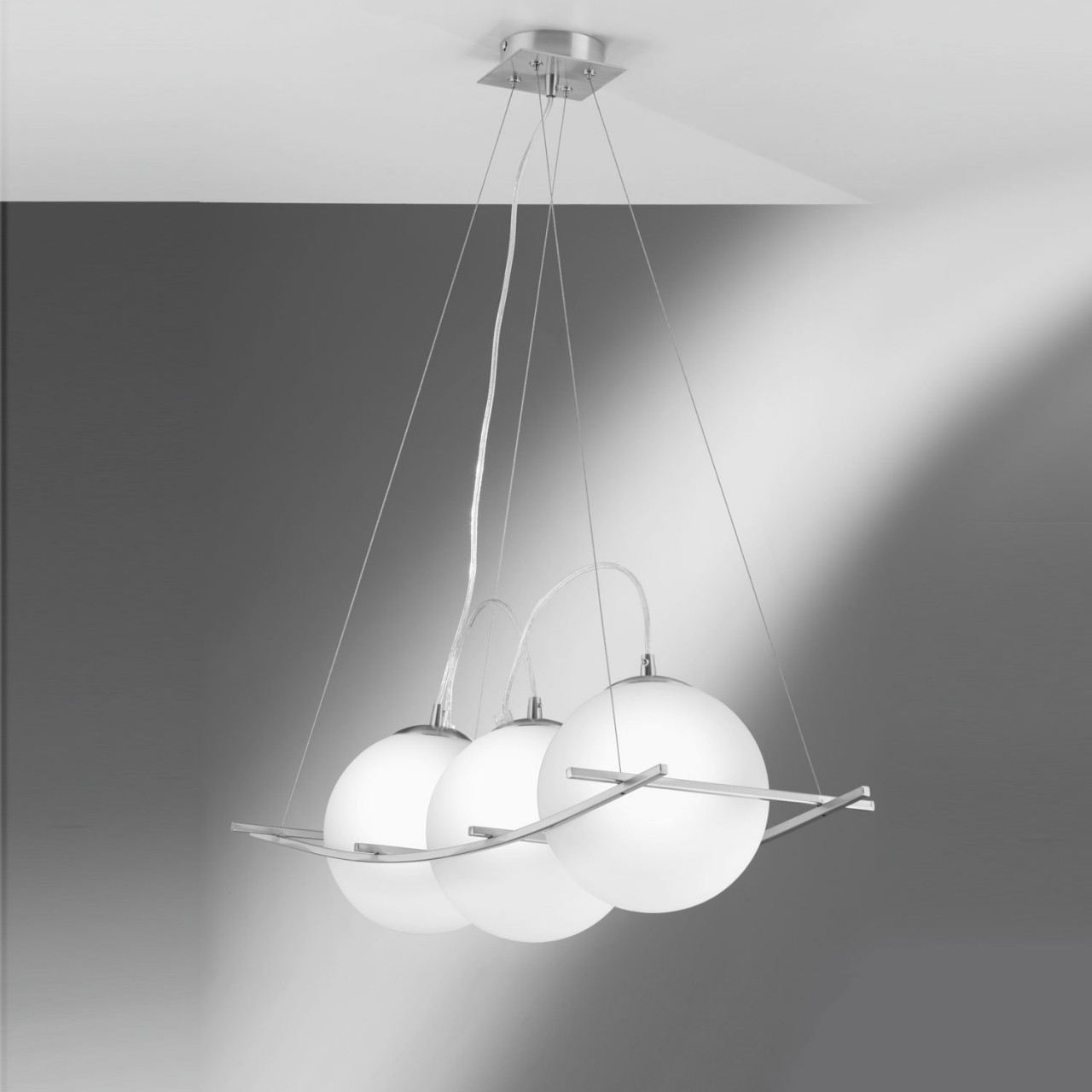 Drei weiße Pendelleuchten mit Kugeln hängen von der Decke, mit silberner Halterung.