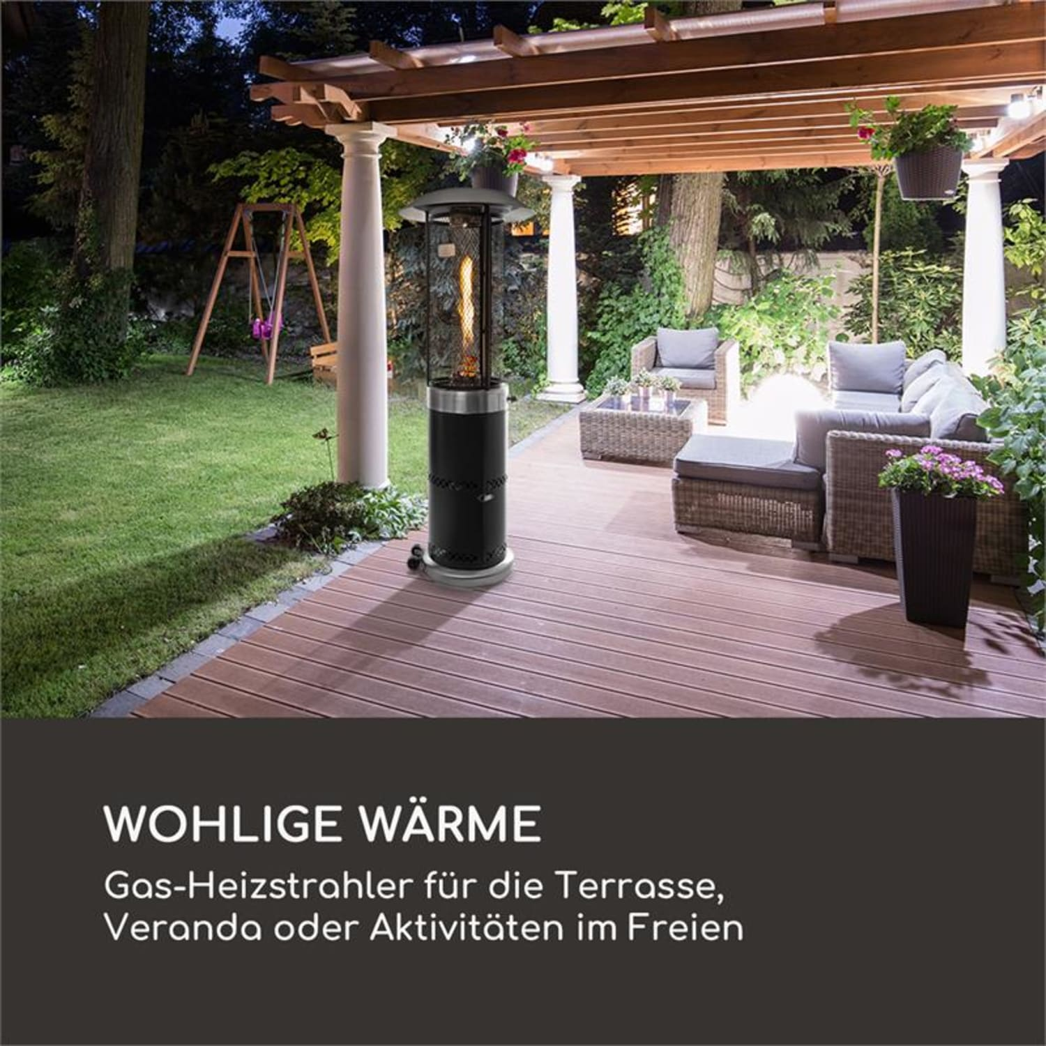Außenterrasse bei Nacht. Gasheizung, Holzterrasse und Sitzgelegenheiten. Bäume und Umgebungsbeleuchtung.