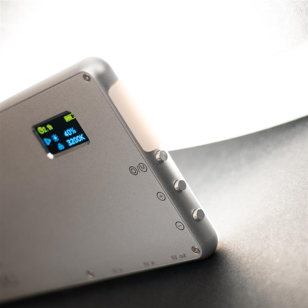 Silberne LED-Leuchte mit Display, das Batterie und Farbtemperatur anzeigt.