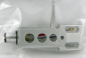 Silberne Audiokartusche mit roten, blauen und grünen Löchern. Silberner Stecker links.