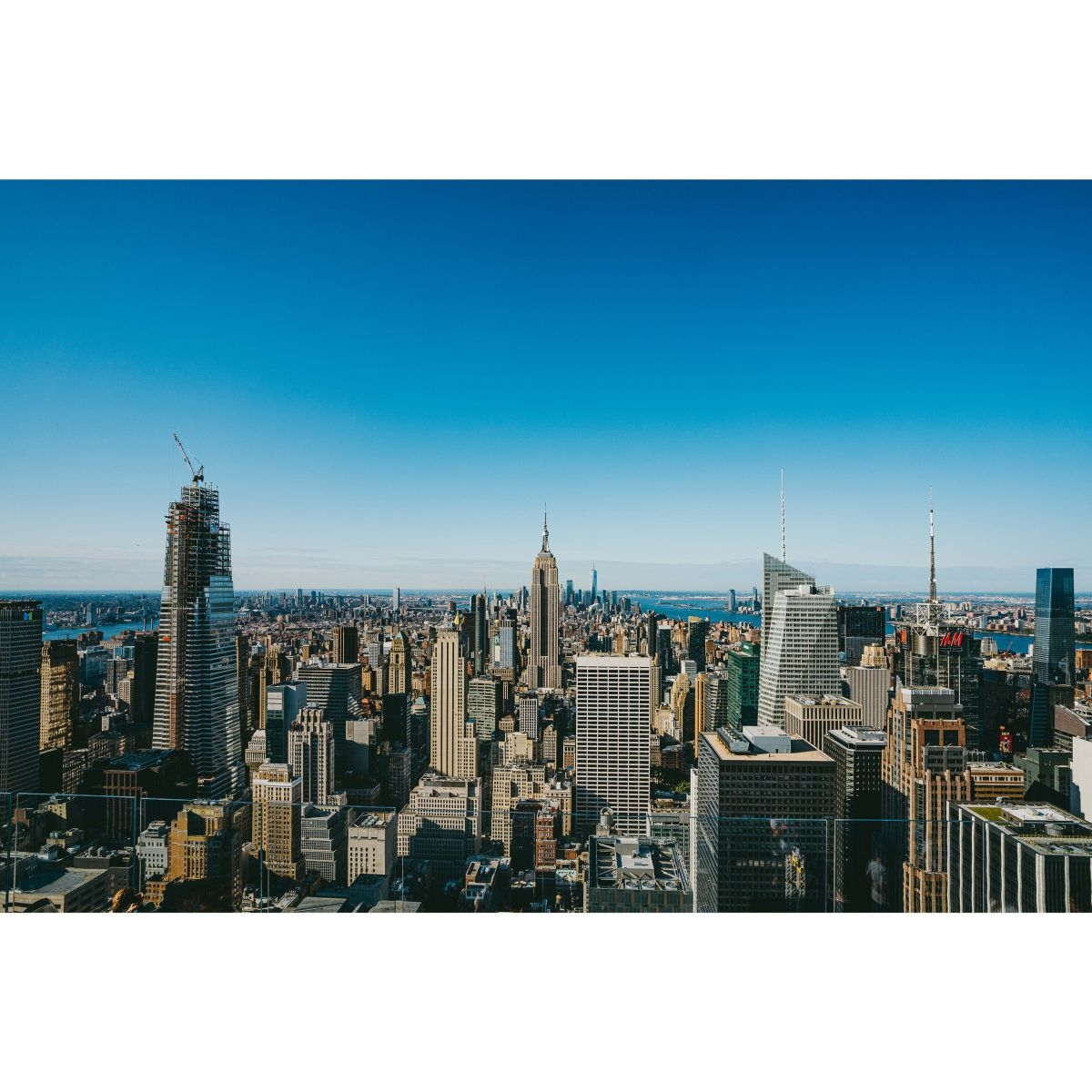 New York City Skyline mit hohen Gebäuden unter einem klaren blauen Himmel.