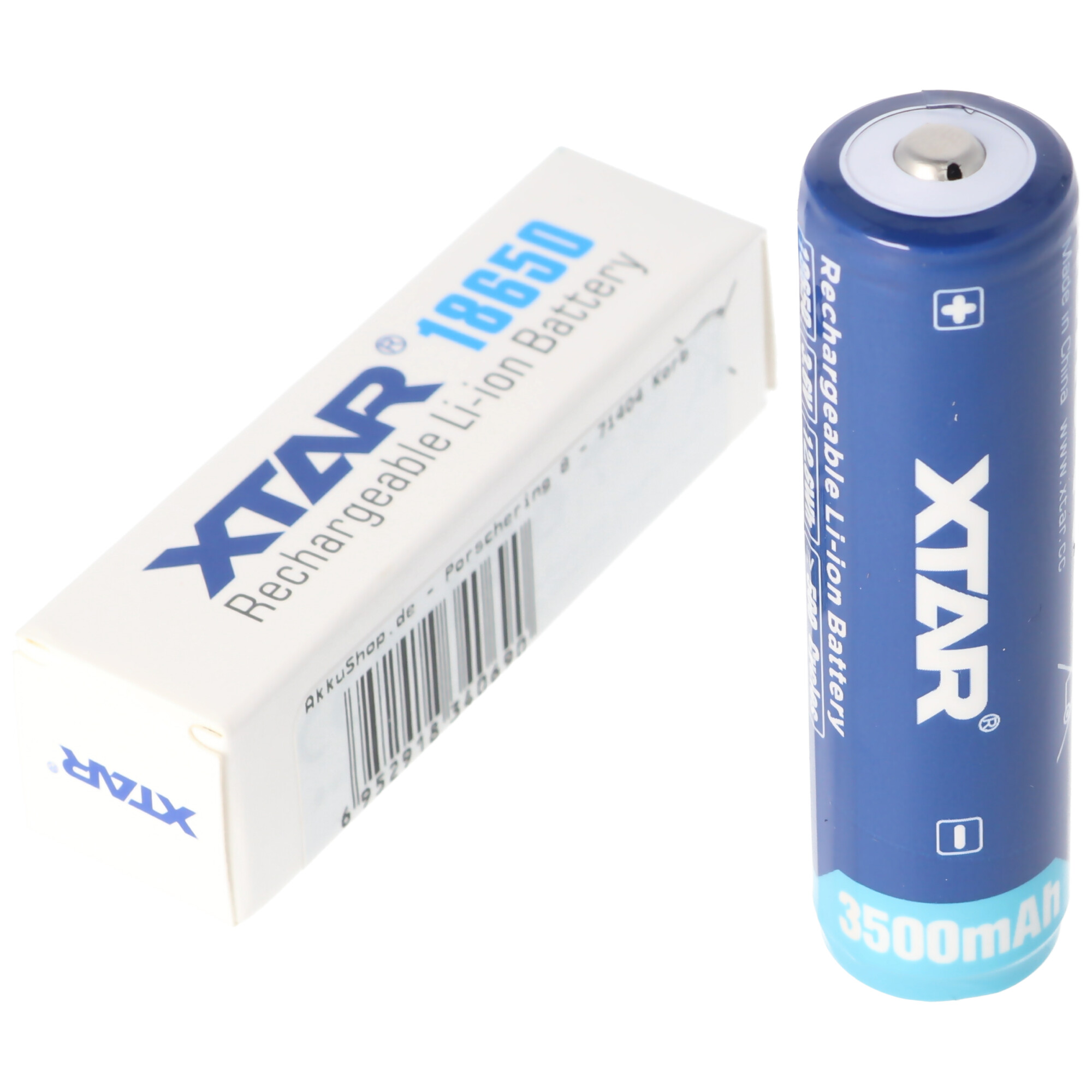Een witte doos en een blauwe en zilveren batterij. De doos zegt 'XTAR' en de batterij zegt '3500mAh'.