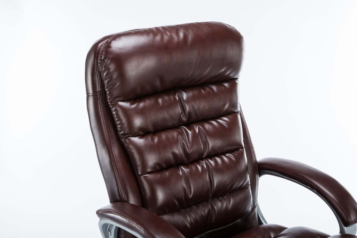 Nahaufnahme einer braunen Leder-Rückenlehne. Der Stuhl ist braun mit gepolstertem Design.