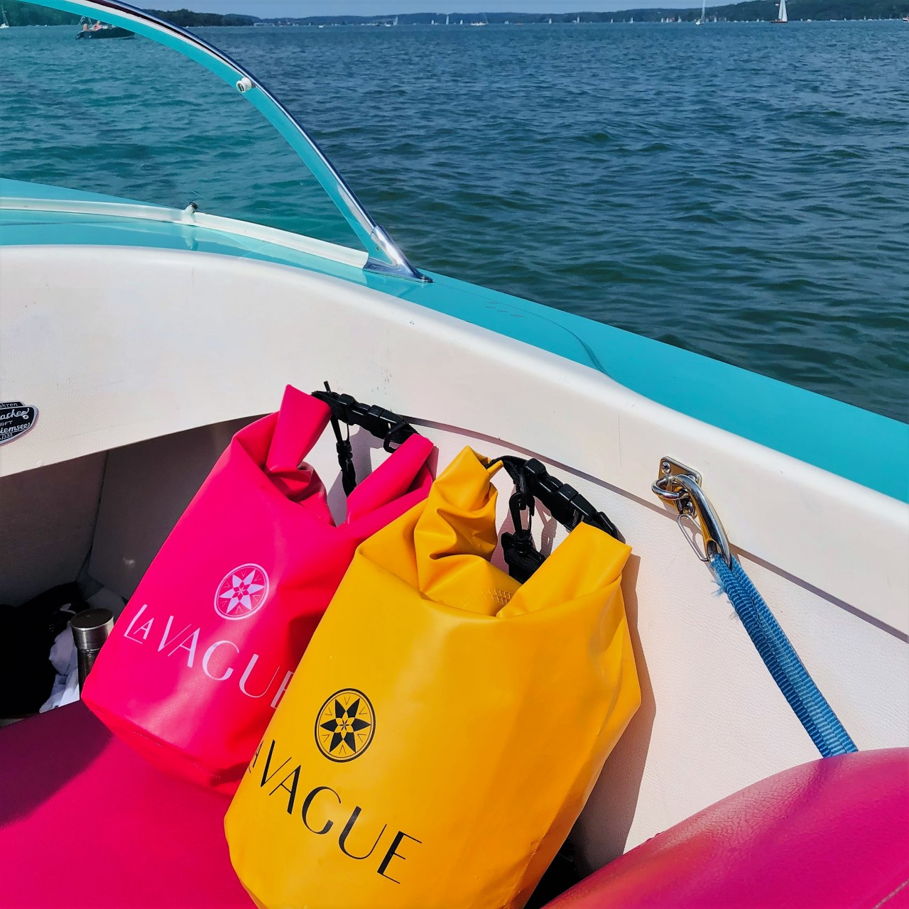 Bolsas secas rosa y amarilla en un barco. Agua y cielo azules al fondo.